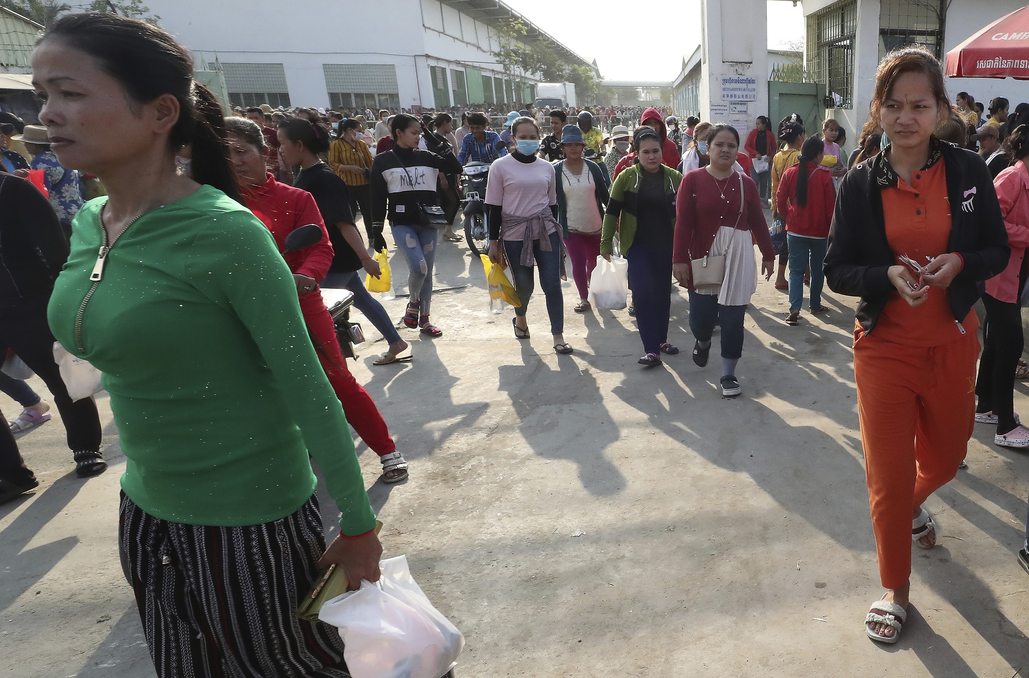 Workers at a garment factory near Phnom Penh walk out at the end of their shift on Tuesday. Photo: AP