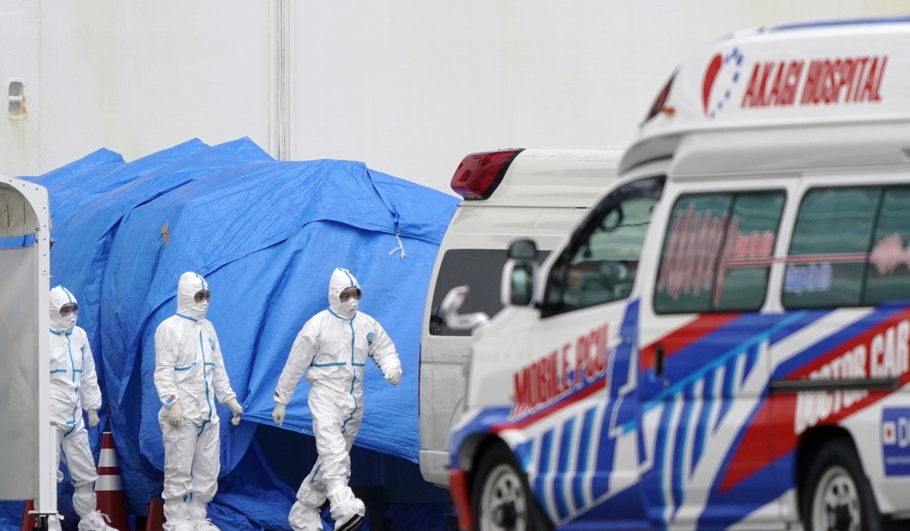 Personnel in protective gear work near ambulances parked before the Diamond Princess cruise ship in Yokohama. Photo: EPA-EFE