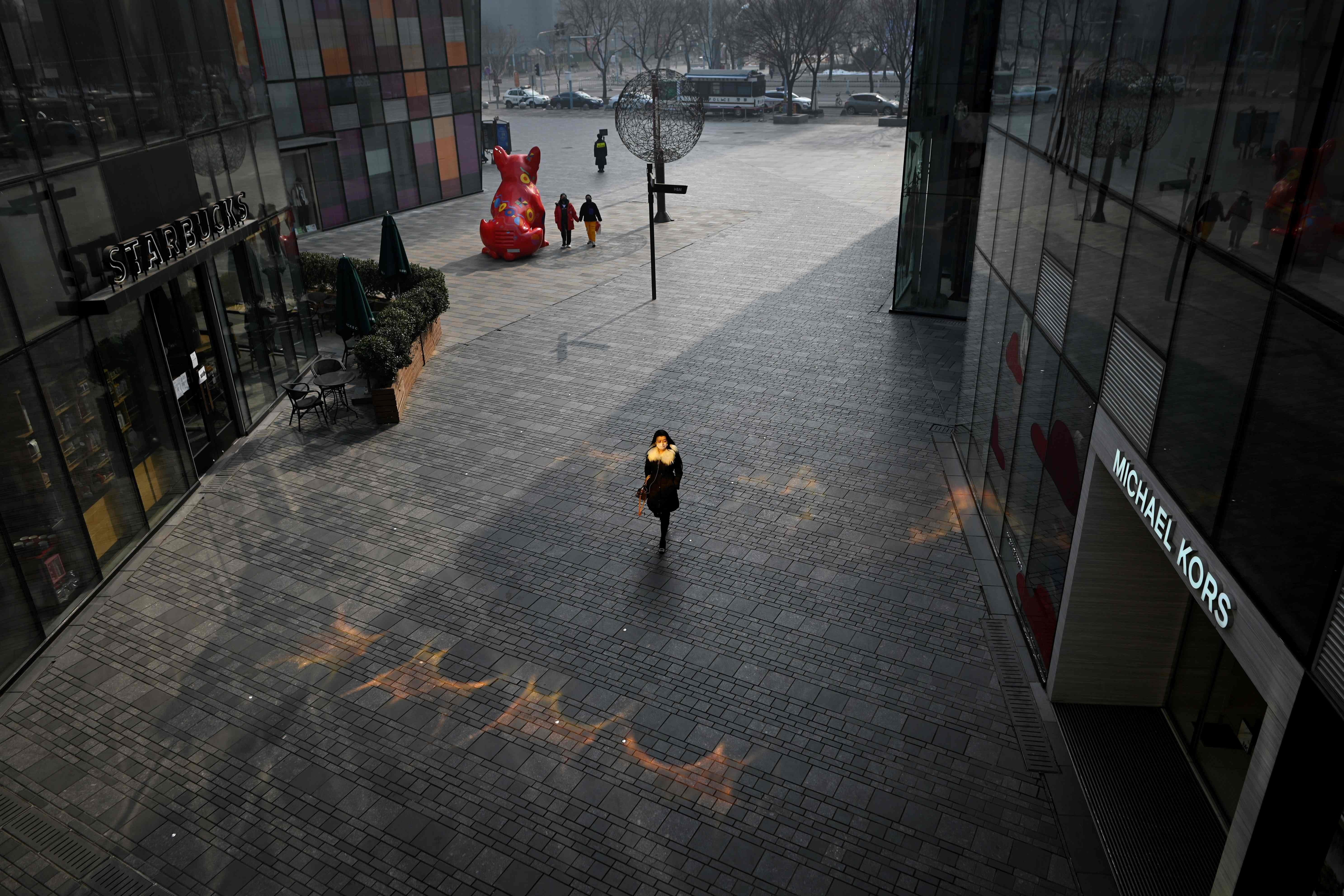 A woman walks through a deserted shopping mall in Beijing. Photo: AFP