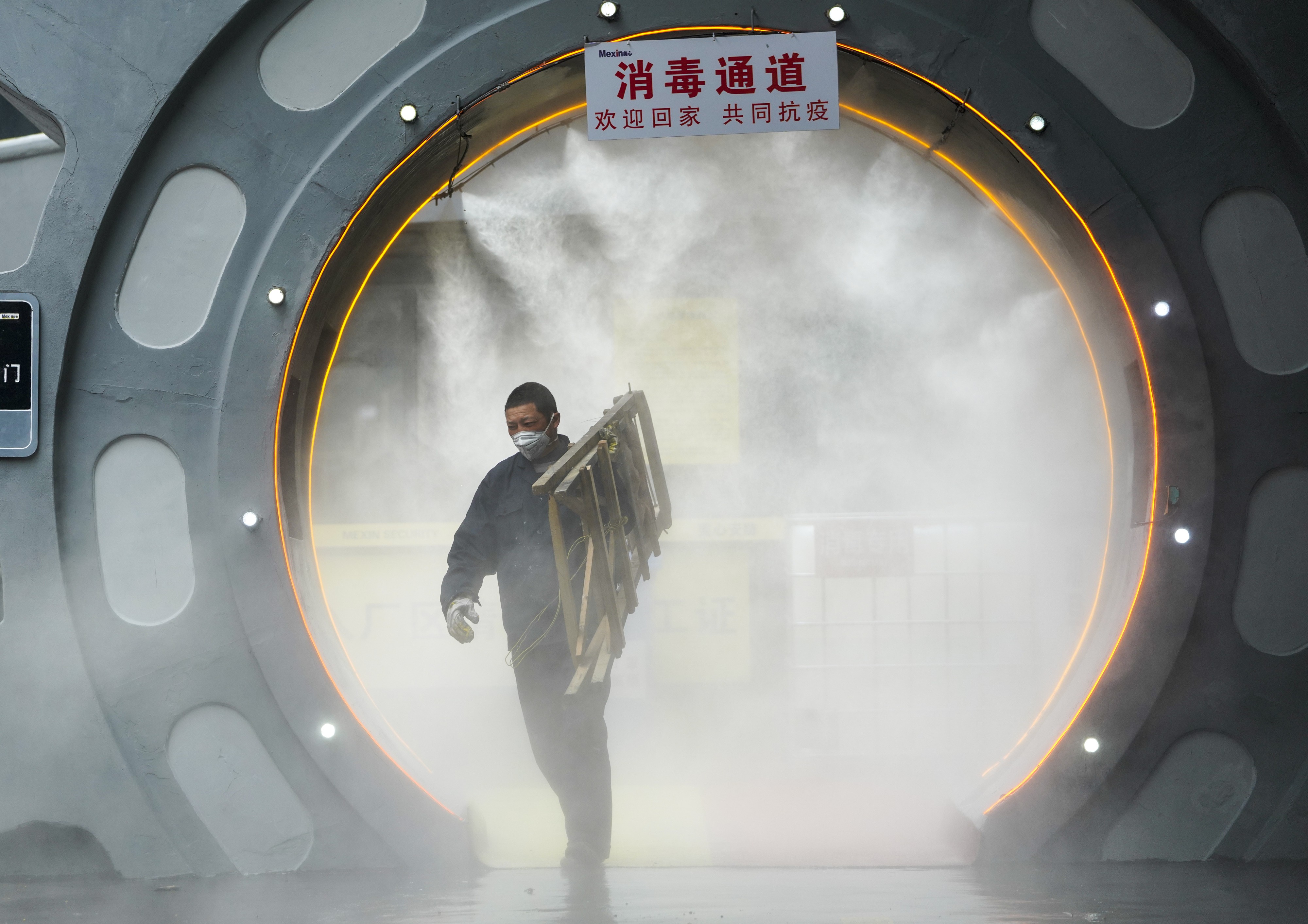 A man walks through a disinfection gate before leaving the work area of Chongqing Mexin Group in southwest China's Chongqing municipality on February 12. Photo: Xinhua