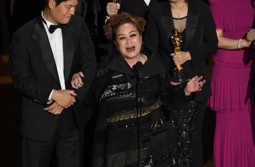 Parasite’s executive producer Miky Lee celebrates on the Oscars stage after the film wins best picture. Photo: Getty Images