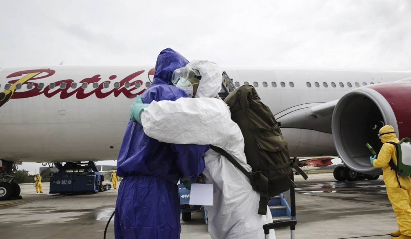 Indonesian health officials arriving from Wuhan, China, being greeted as they land at Hang Nadim Airport in Batam, Indonesia. Photo: EPA