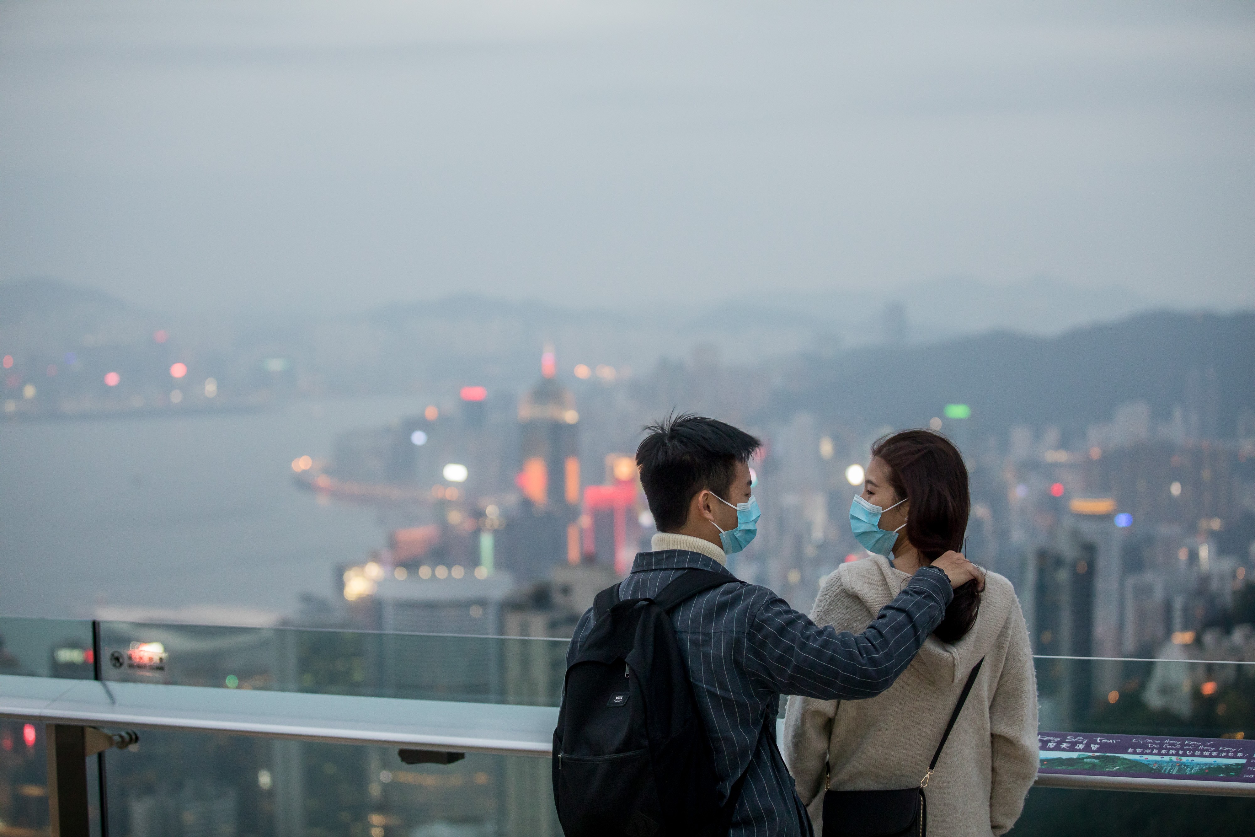 People wearing protective masks stand on a viewing terrace at Victoria Peak in Hong Kong on February 3. Hong Kong needs strong community bonds, including those between the government and people, to survive the coronavirus and other crises. Photo: Bloomberg