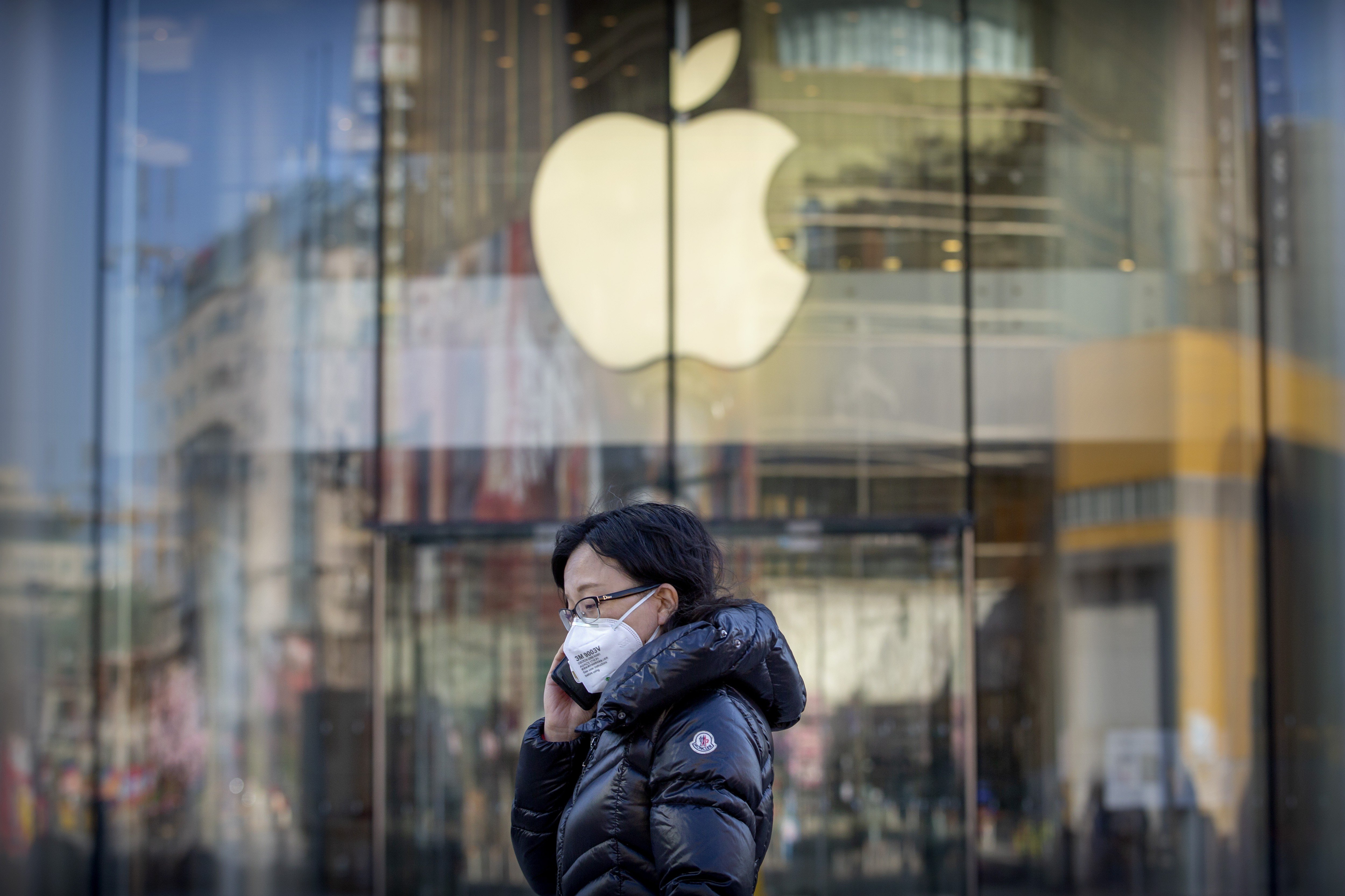 A woman wearing a mask walks past a temporarily closed Apple store in Beijing on February 4. The American tech giant has closed all stores in China due to the coronavirus outbreak. Photo: AP