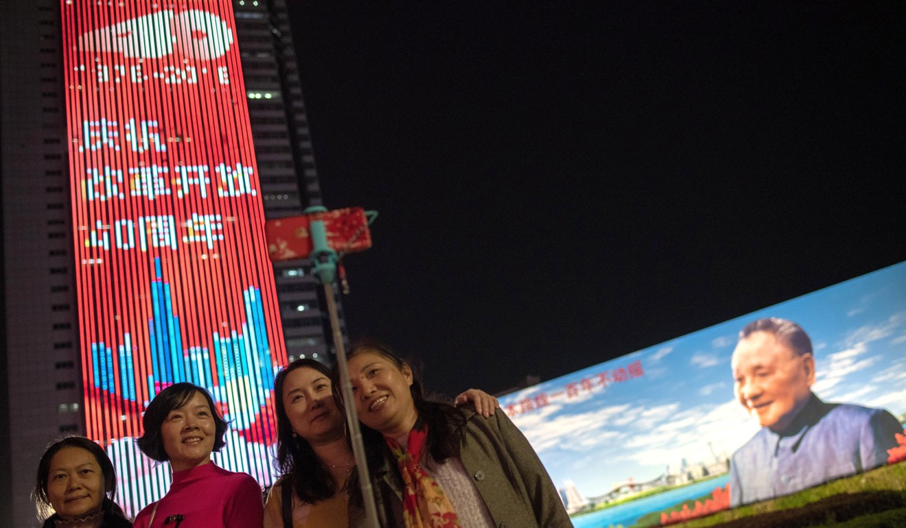 People take a selfie in front of a billboard in Shenzhen featuring China’s late paramount leader Deng Xiaoping on the eve of the 40th anniversary of China's “reform and opening up” policy in Shenzhen. Photo: AFP