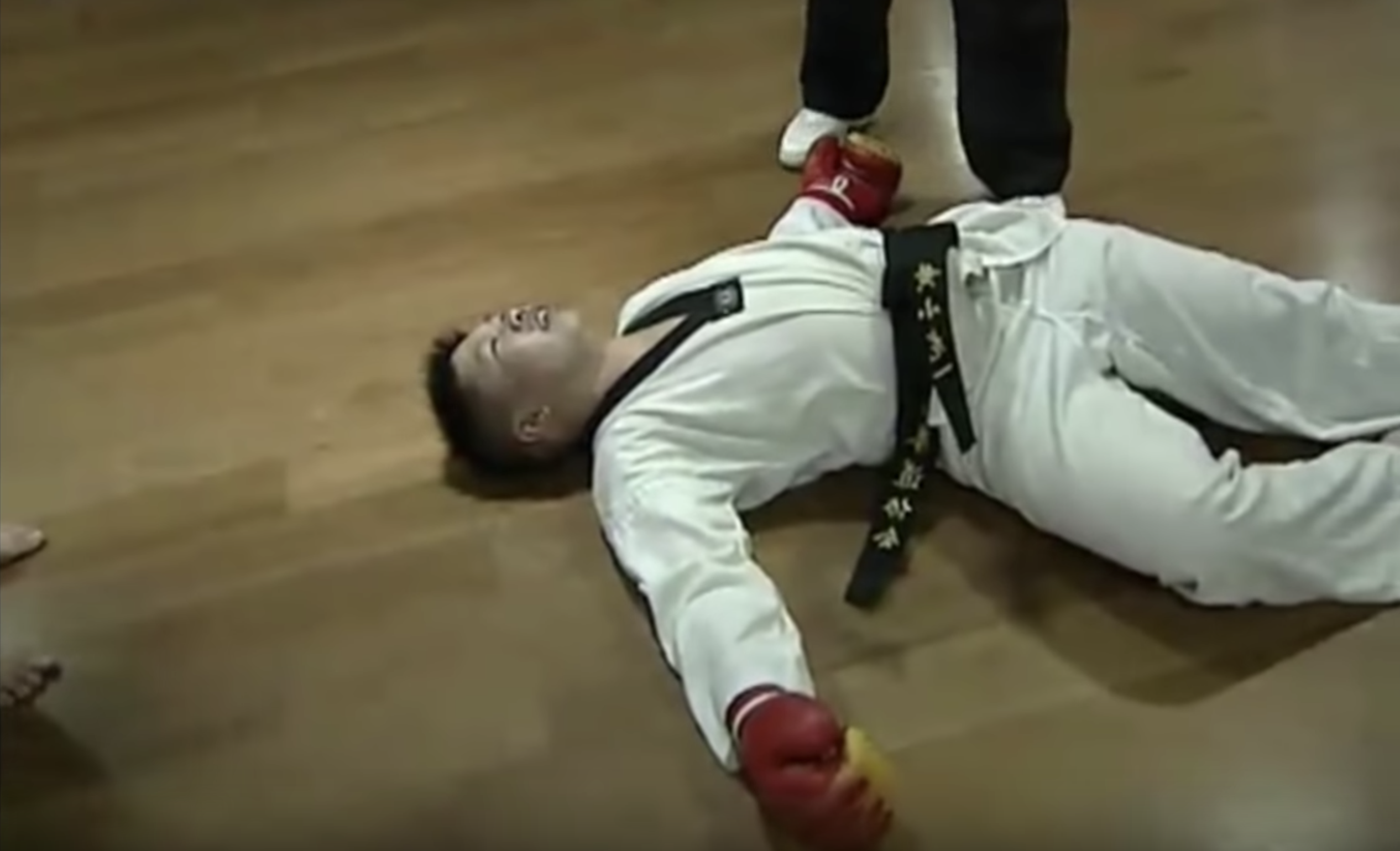 Chinese World Taekwondo Federation black belt Huang Xiaolong lies concussed on the floor. Photo: YouTube/Fight Commentary Breakdowns