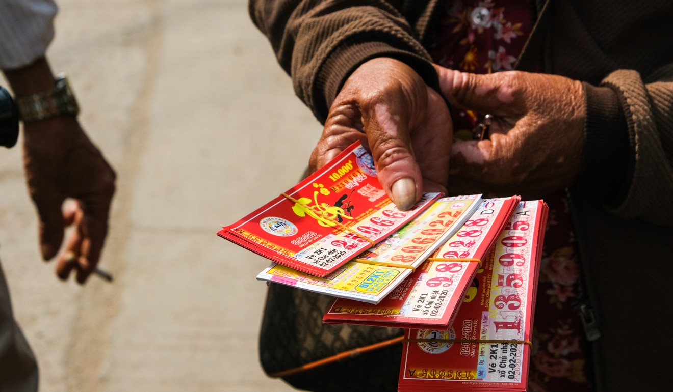 A Khmer street seller in Chbar Ampov with a fistful of Vietnamese lottery tickets for sale. Photo: Peter Ford