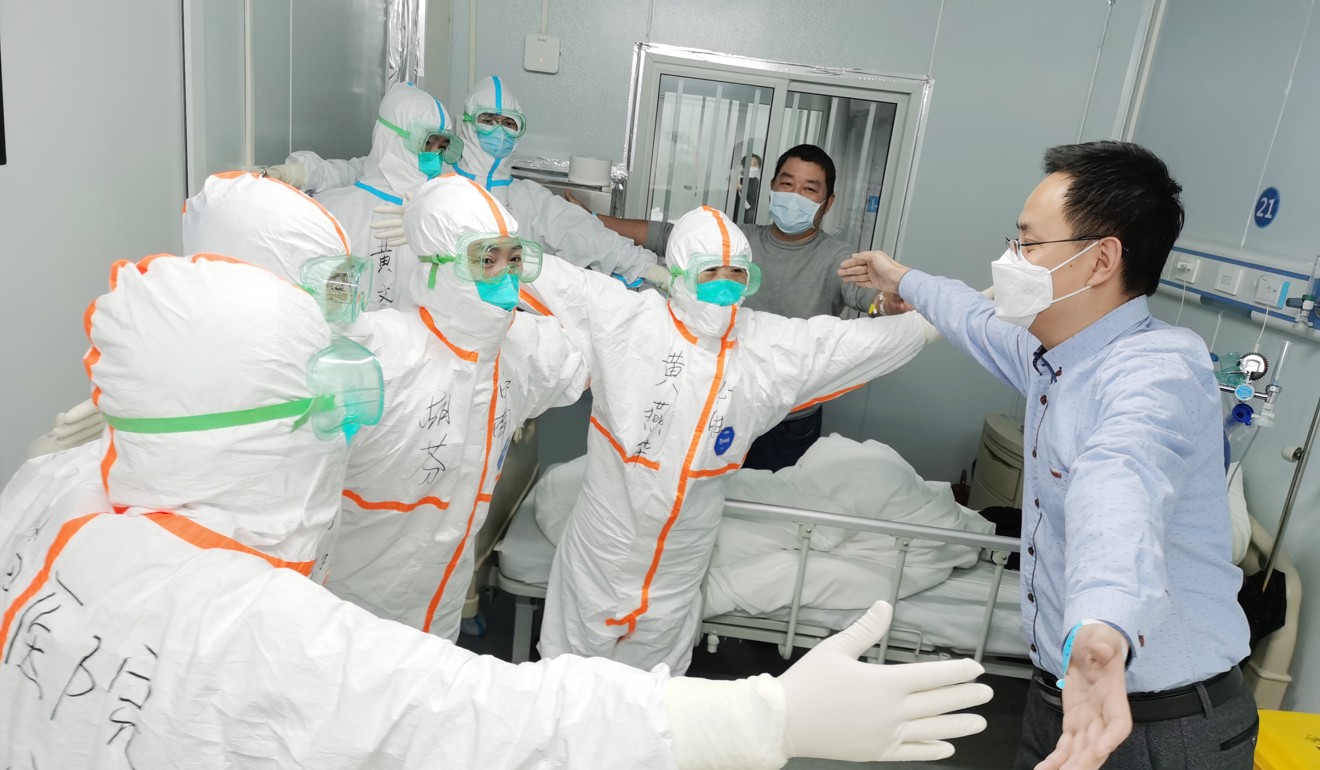 A recovered coronavirus patient “hugs” medical staff without body contact before leaving Leishenshan (Thunder God Mountain) Hospital in Wuhan. Photo: Xinhua