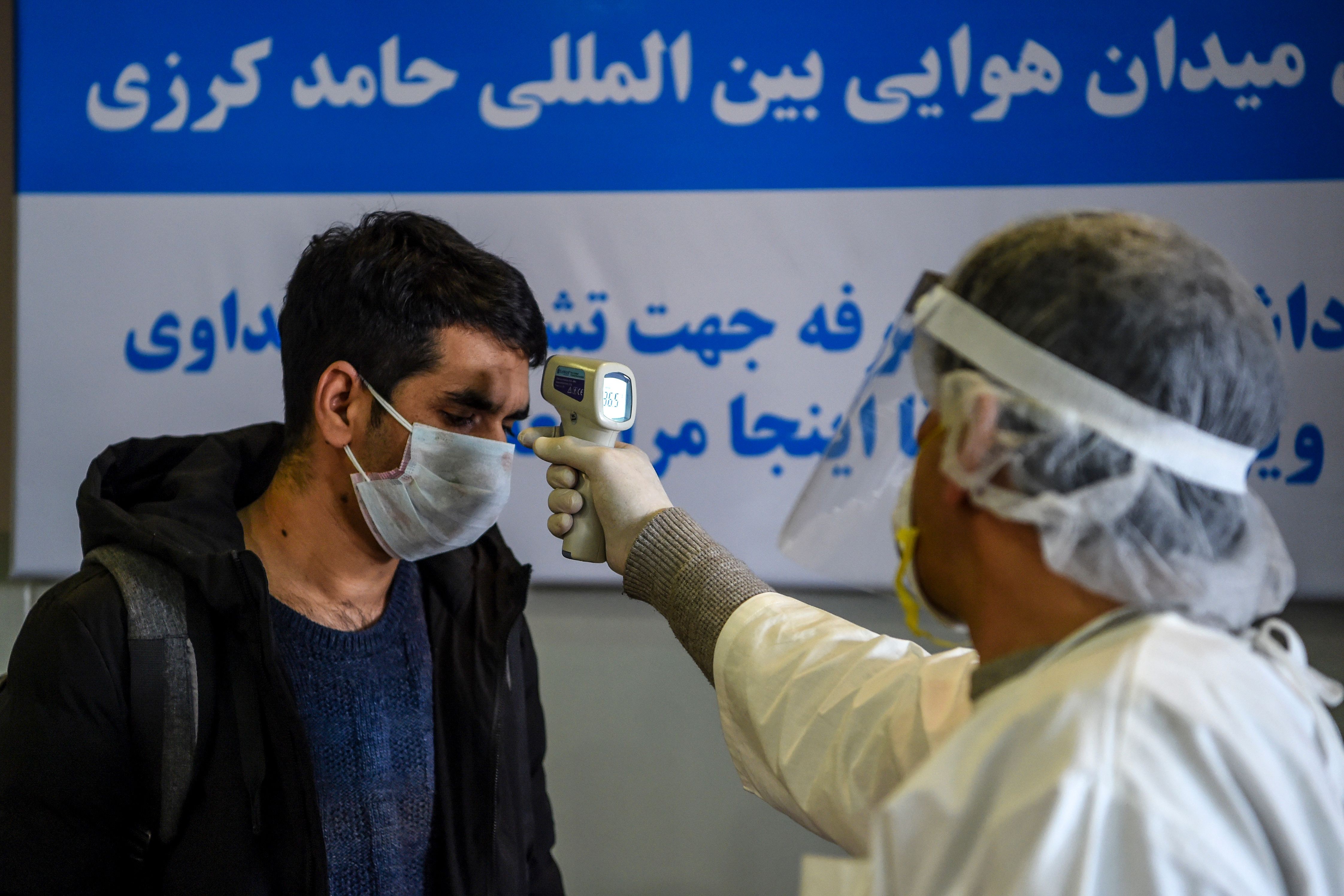 A health worker wearing protective gear checks a passenger’s temperature at Hamid Karzai International Airport in Kabul earlier this month. Photo: AFP