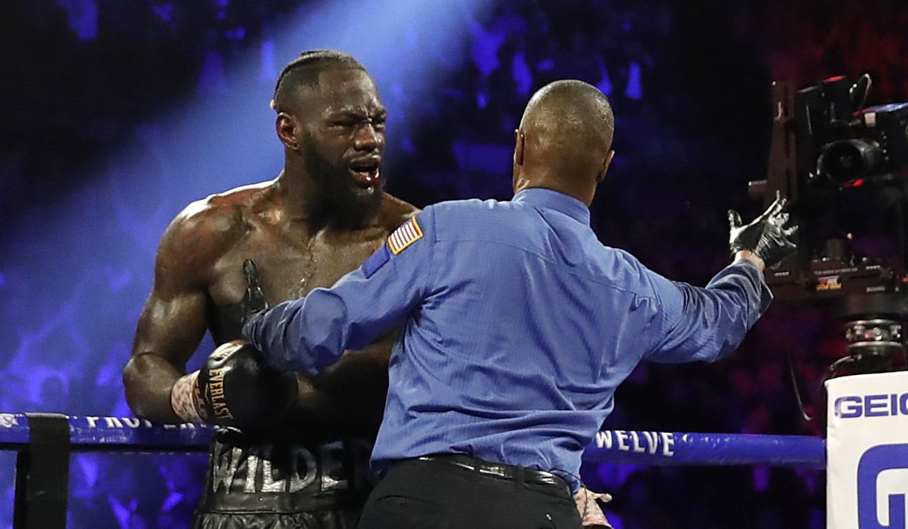 A beaten Deontay Wilder realises his corner has thrown in the towel. Photo: Reuters