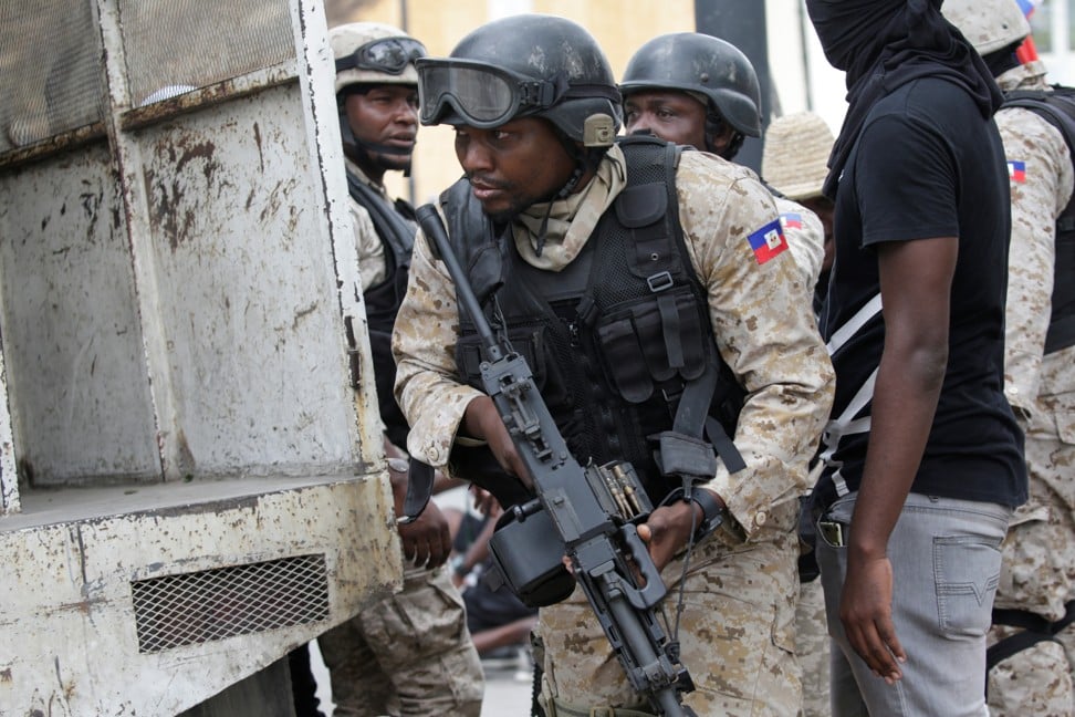 A Haitian National Police officer looks on during the shoot-out. Photo: Reuters