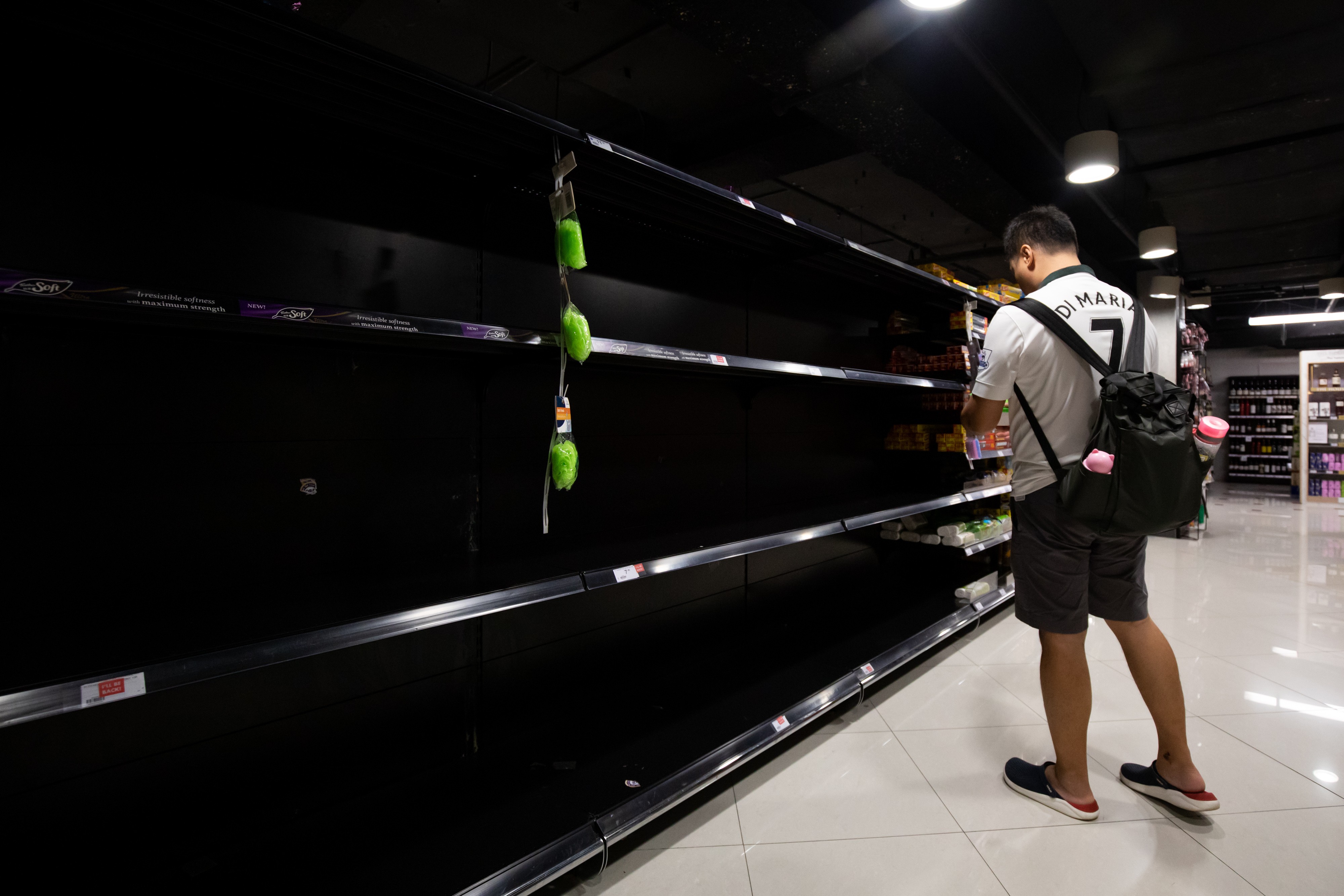 A customer stands in front of empty shelves in the toilet paper aisle of a supermarket in Singapore on February 8. Photo: Bloomberg