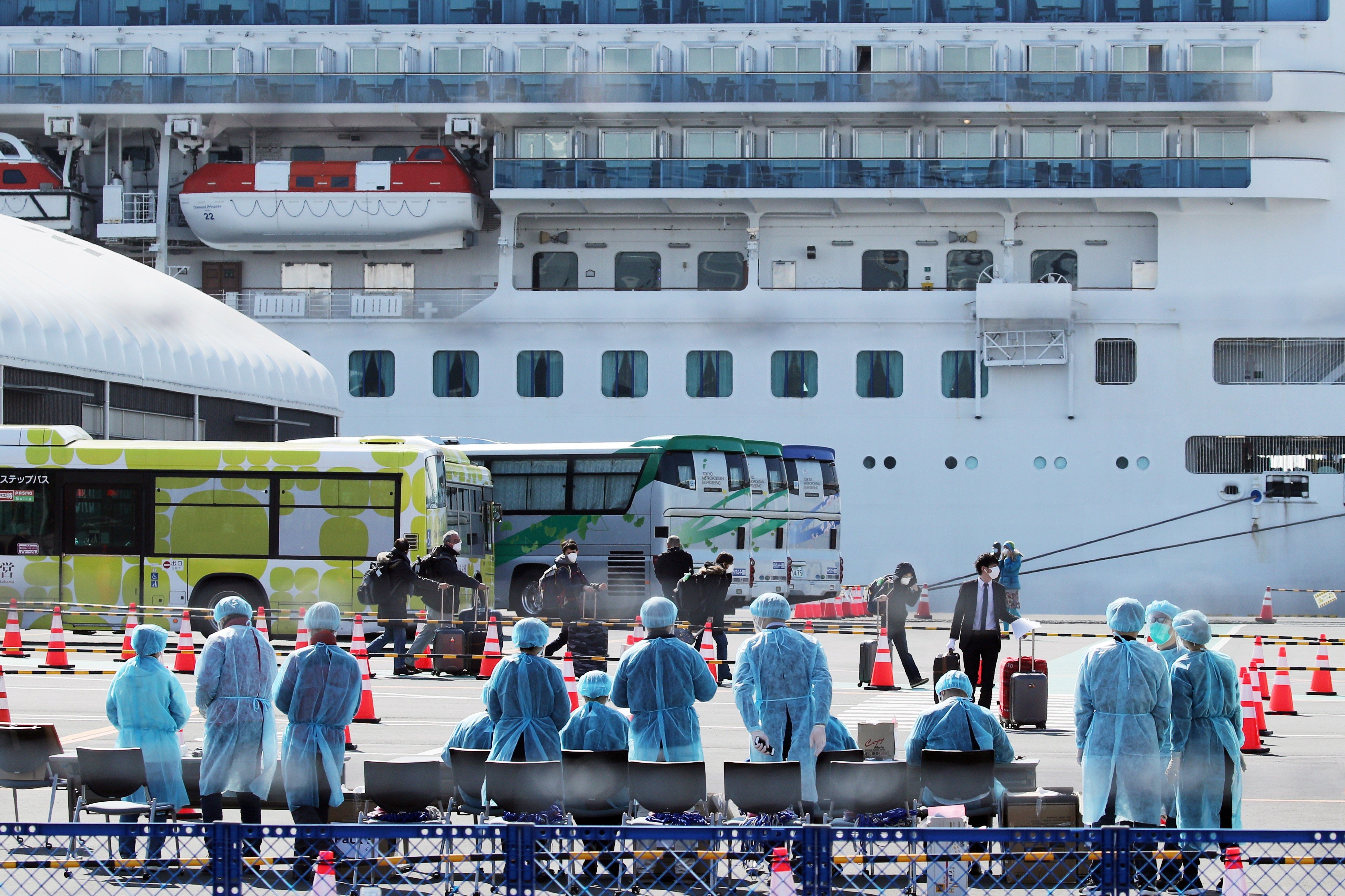 Workers in protective gear prepare to check passengers after they disembarked the Diamond Princess cruise ship, which has been quarantined, at the Daikoku Pier Cruise Terminal in Yokohama, Japan. Photo: EPA-EFE