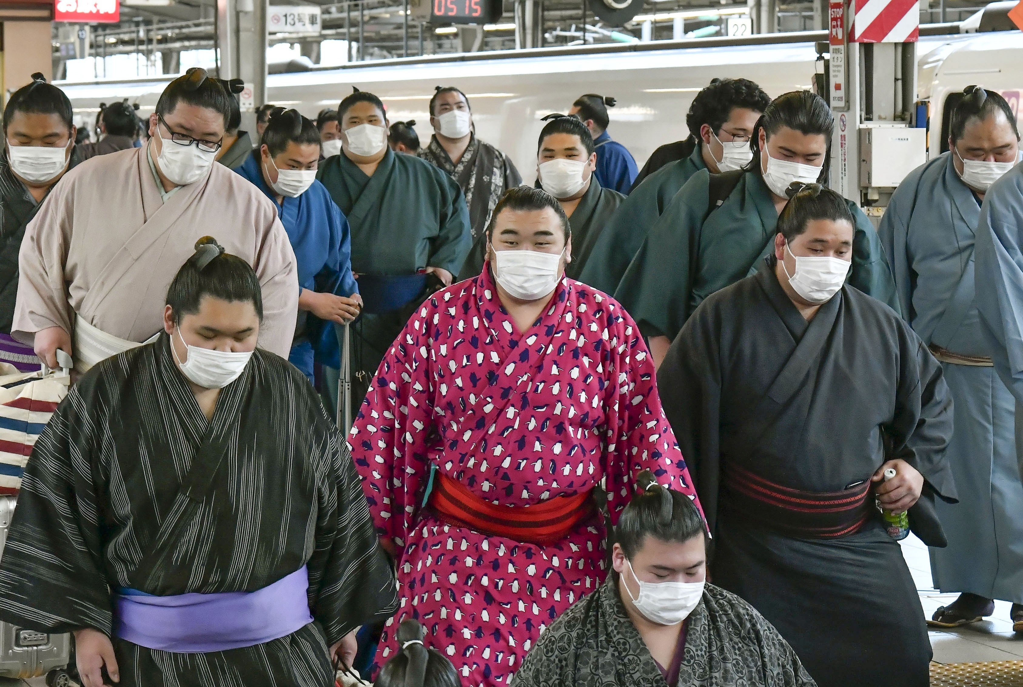 Sumo wrestlers wearing masks arrive at Shin Osaka railway station in Japan on February 23, as Japan grapples with the coronavirus outbreak. Photo: Kyodo News