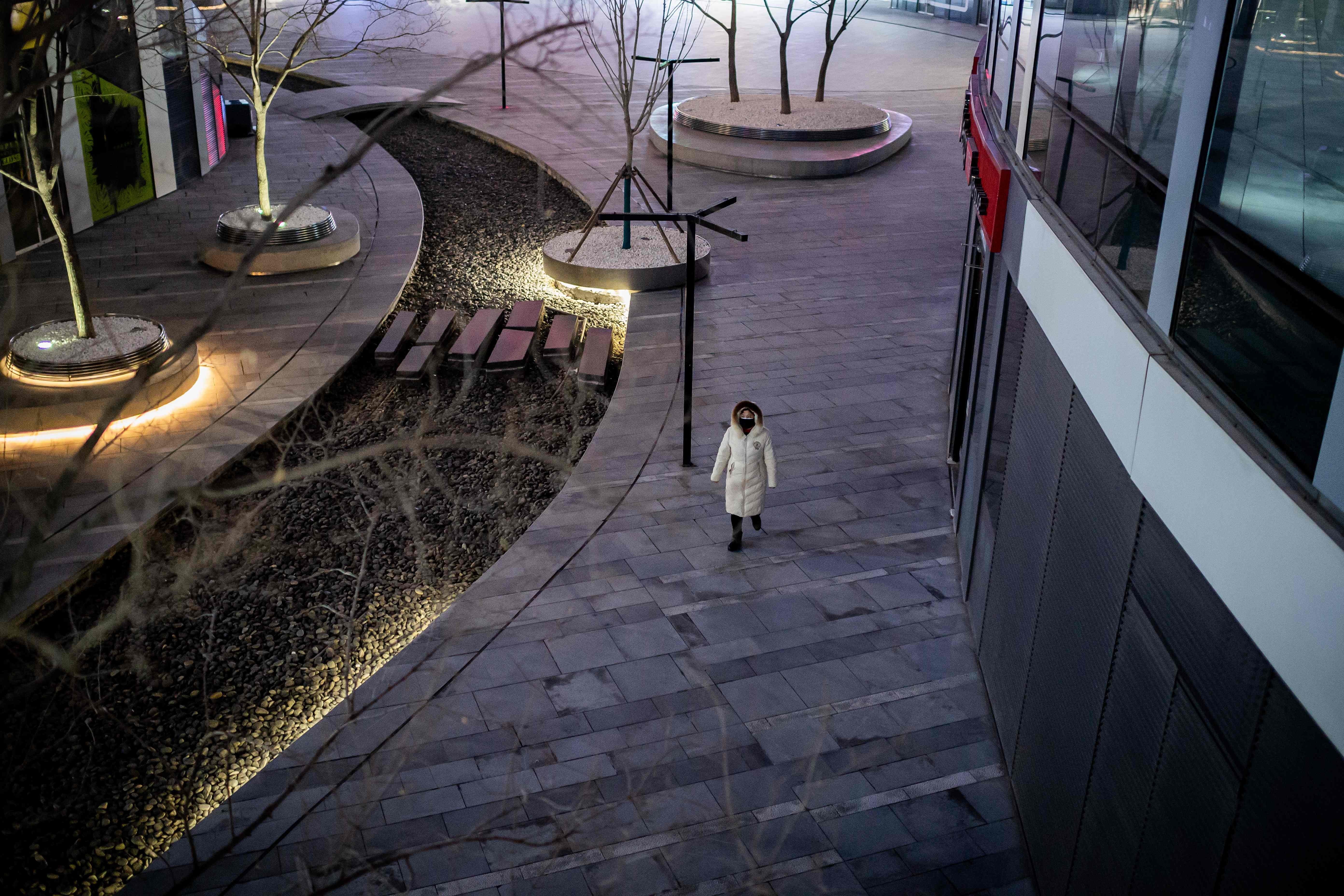 A woman wearing a protective face mask walks in a nearly empty shopping mall in Beijing on February 24. A recent survey of 900 consumers suggests that pent-up demand within China’s Tier-1 cities will help fuel a recovery. Photo: AFP