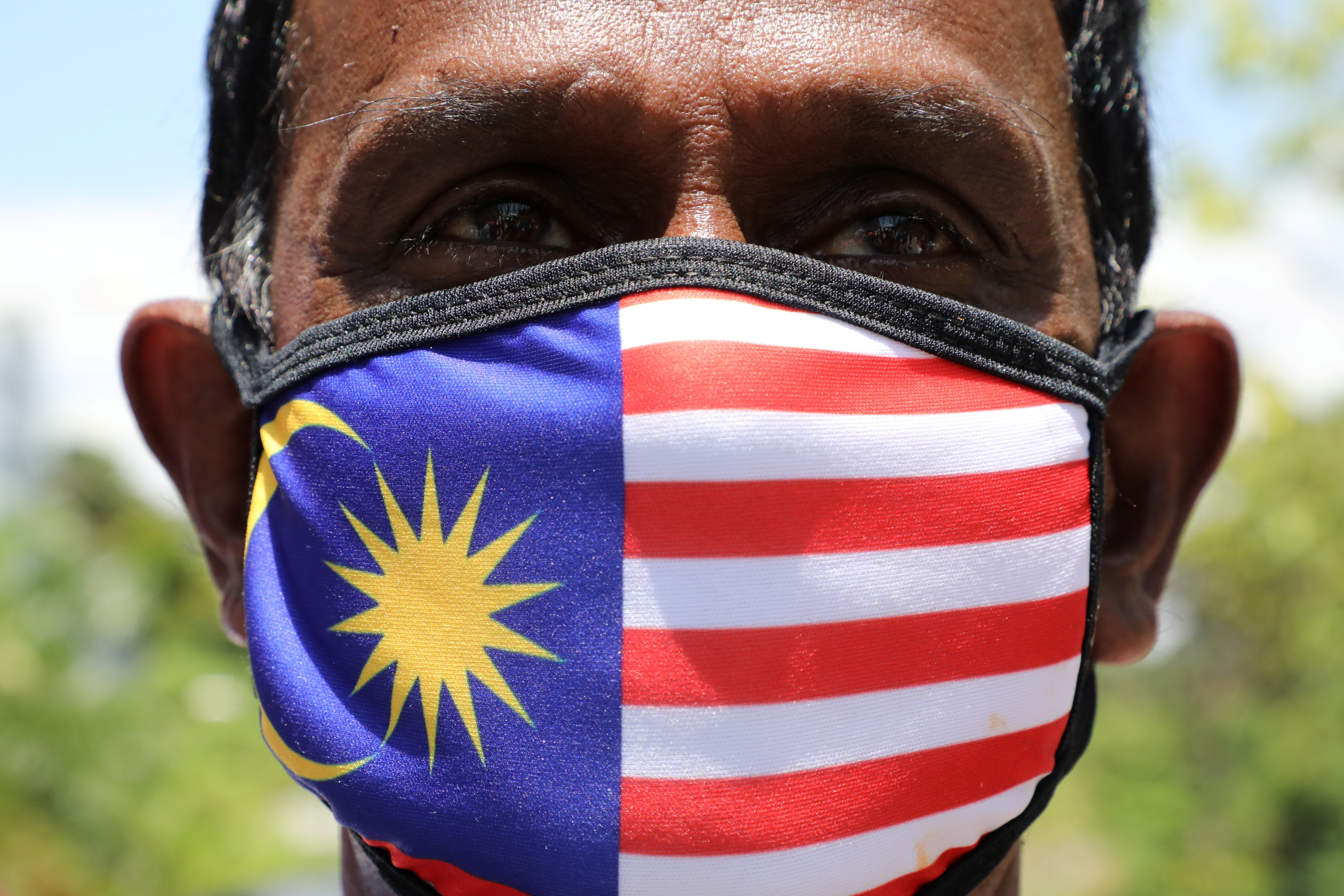 A supporter of the People's Justice Party wears a Malaysian flag face mask outside the National Palace in Kuala Lumpur. The recent high-profile resignations have caused political instability in the country as it handles the coronavirus outbreak. Photo: Reuters