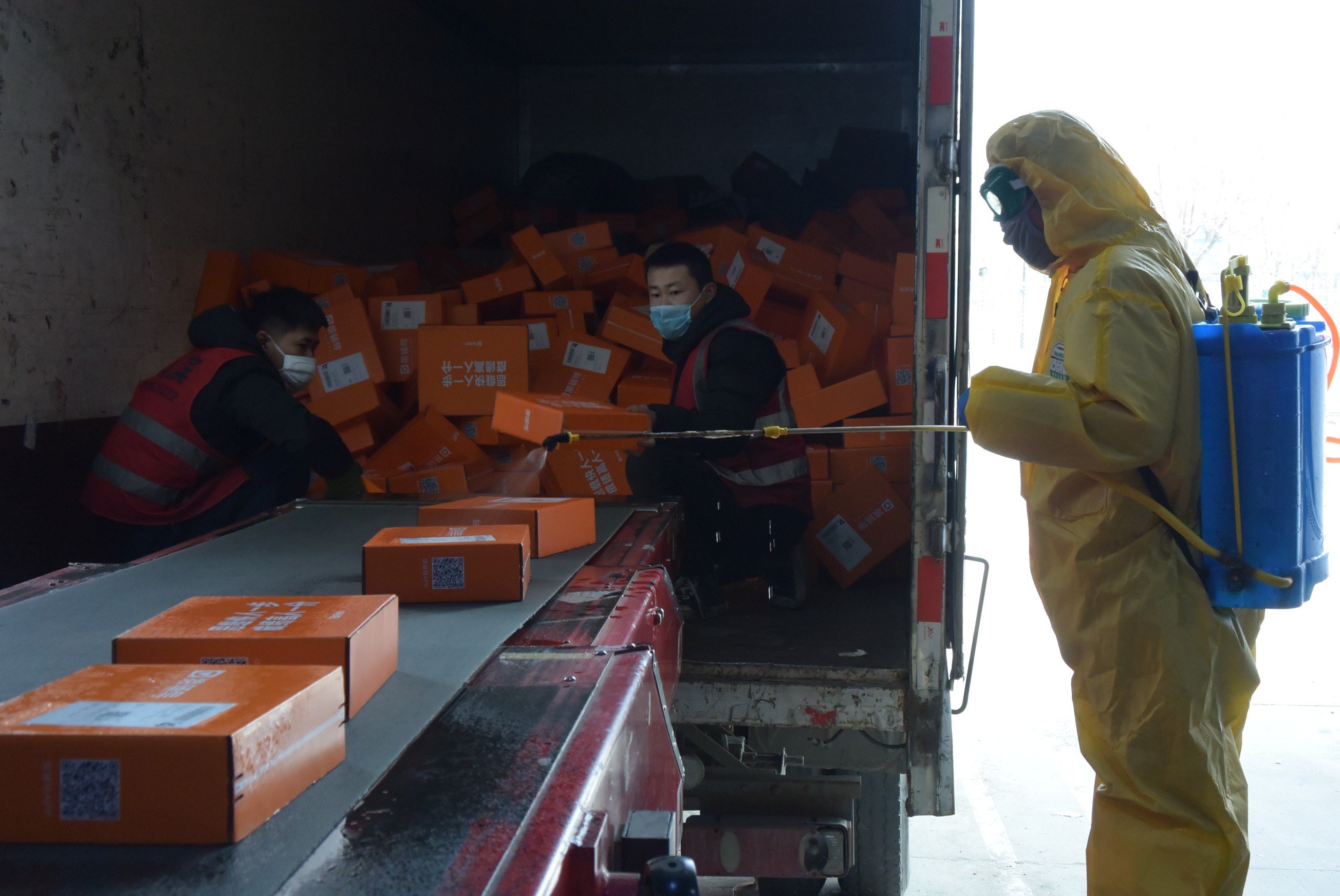 An employee disinfects packages at a distribution centre of SF Express in north China's Tianjin. Photo: Xinhua