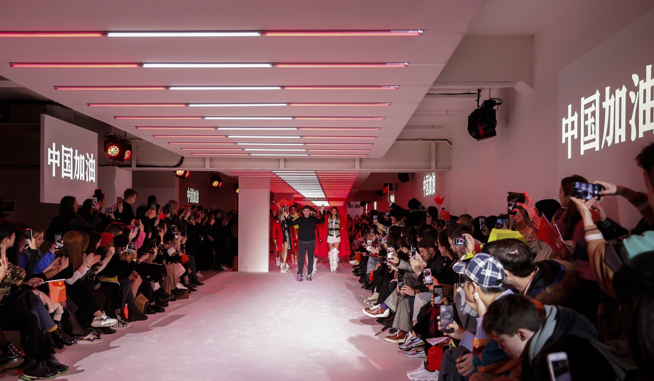 People wave Chinese national flags at the end of the Bosideng show at London Fashion Week. Photo: Xinhua/Han Yan