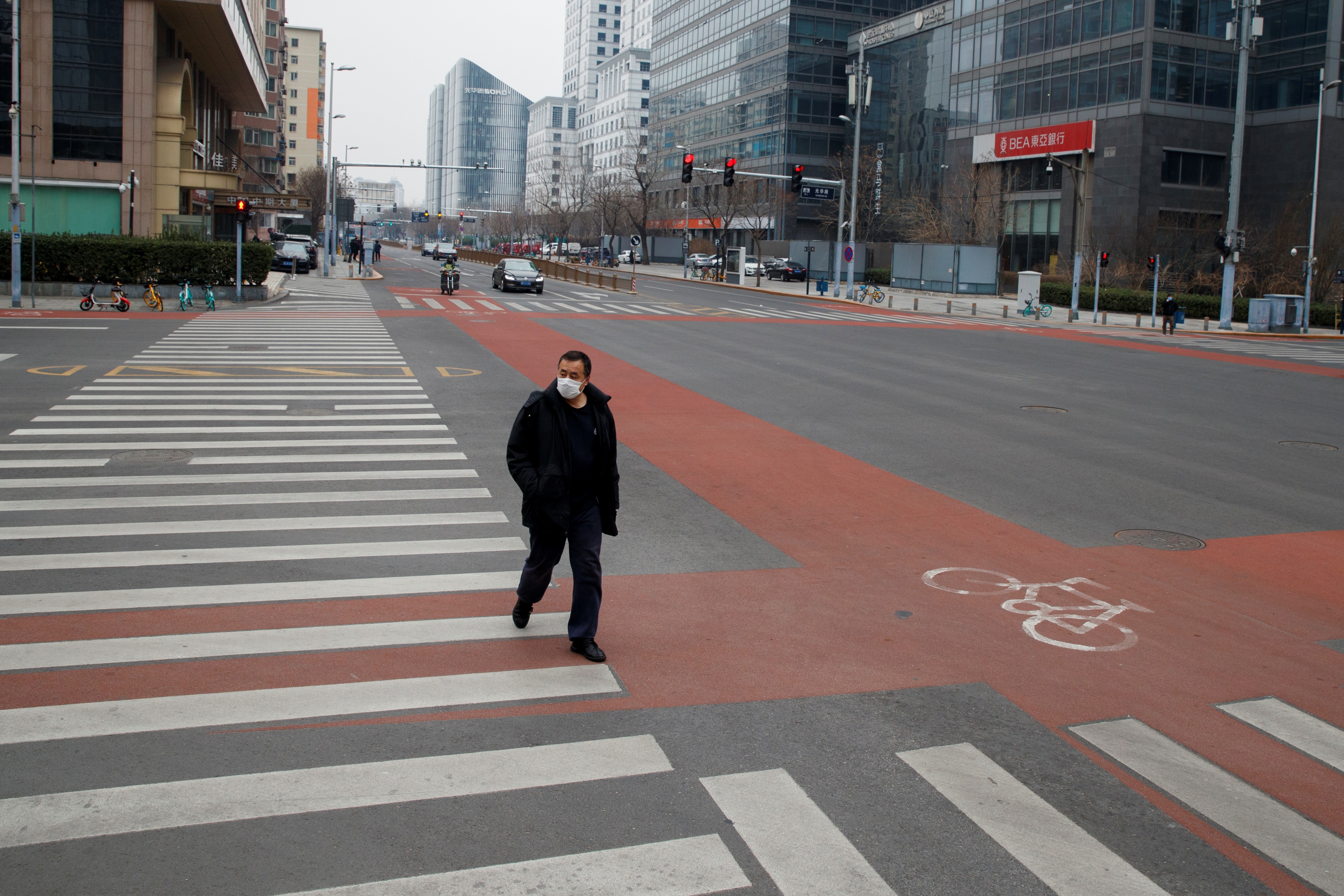 A man crosses the road in the practically deserted central business district in Beijing on February 24. Photo: Reuters