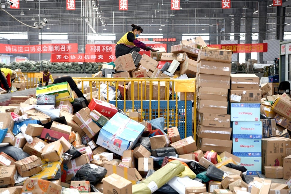 Staff, wearing masks, of a local express factory deal with parcels in Huainan city, Anhui province. Photo: Imaginechina