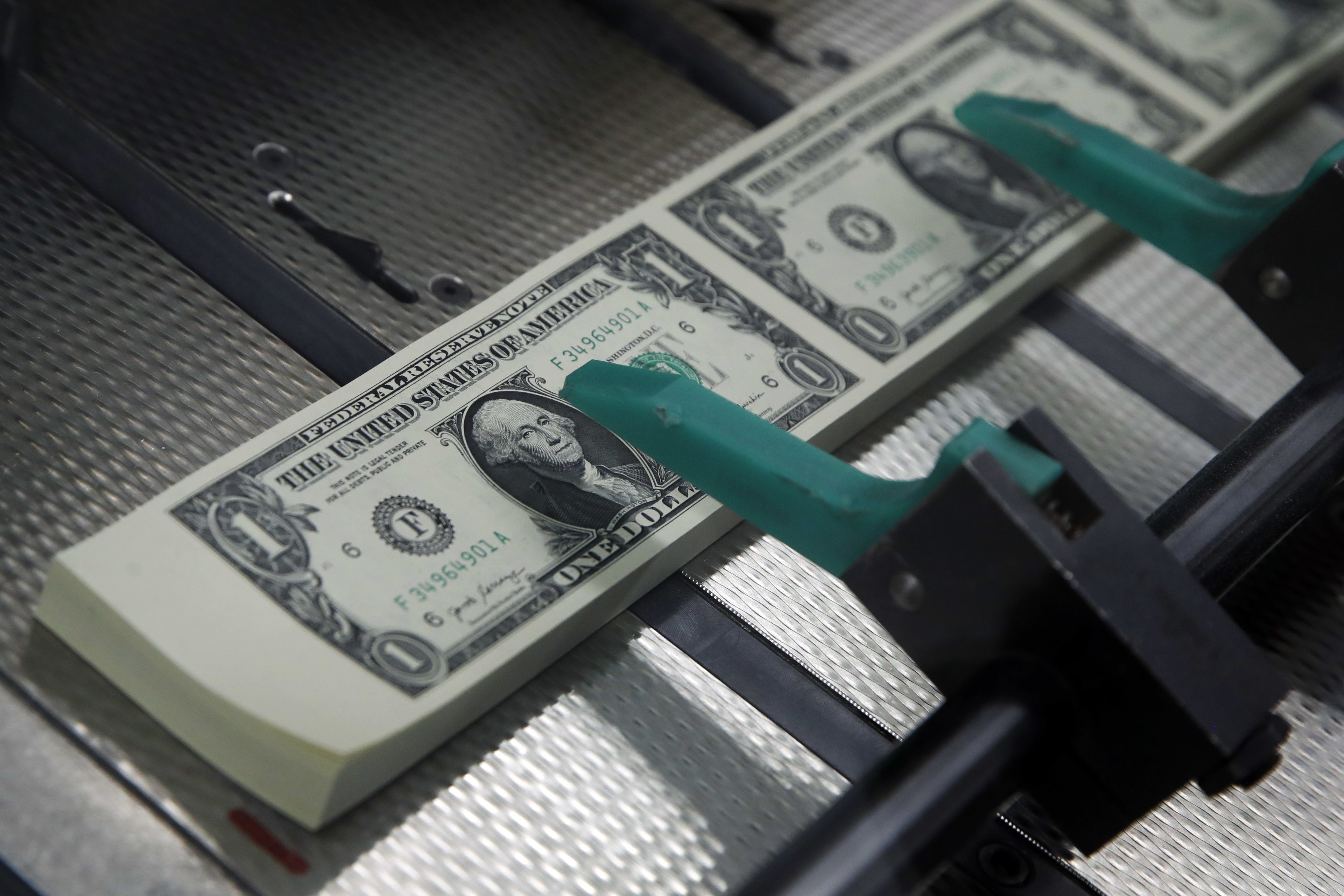 New US dollar bills are cut and stacked at the US Bureau of Engraving and Printing in Washington in 2017. The US government bond market is the most expensive it has ever been, and the period of low interest rates and cheap money is often viewed as the culprit. Photo: AP