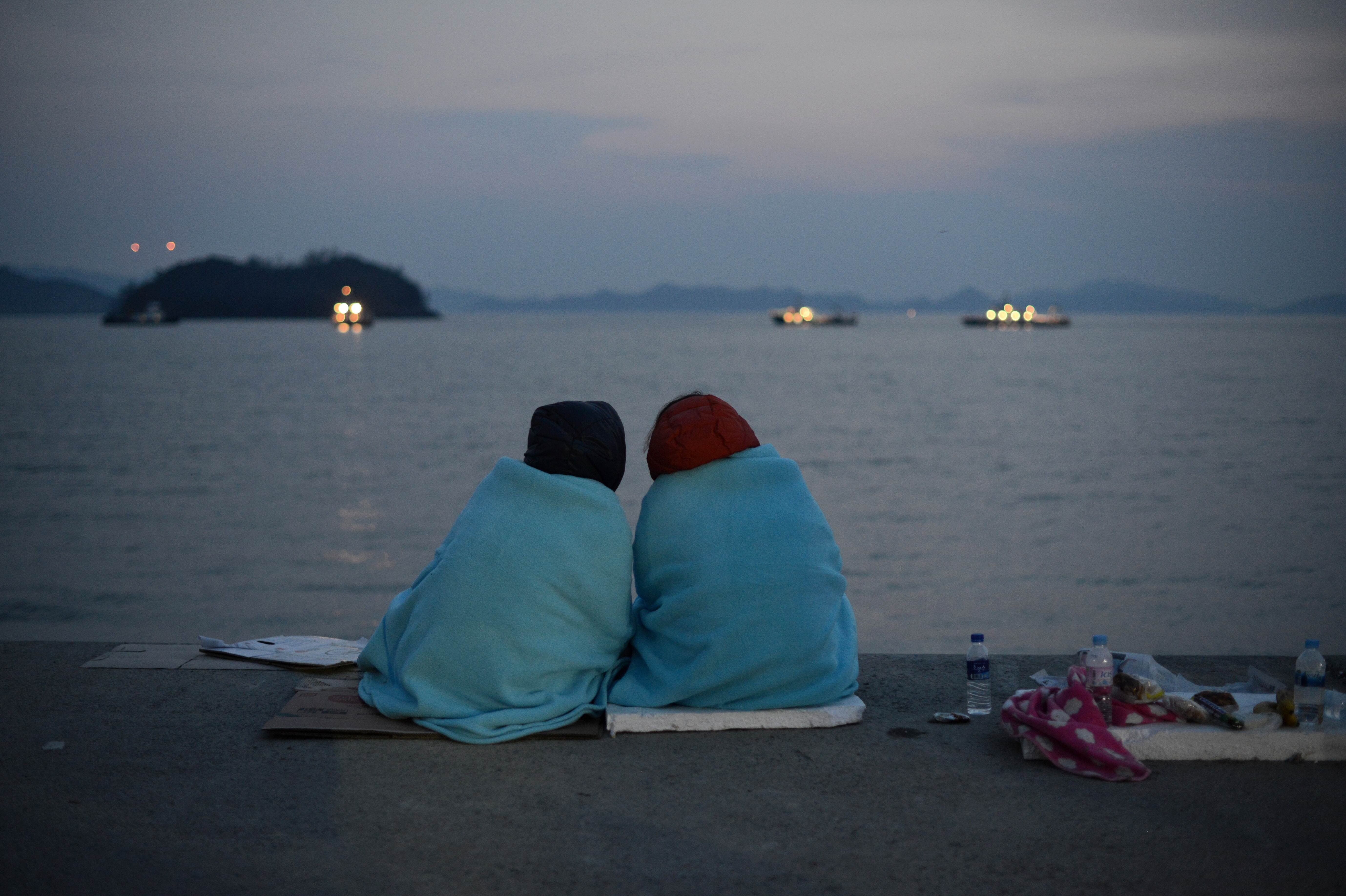 Relatives of victims of the sinking of the South Korean ferry Sewol sit at Jindo harbour as divers search for bodies. Photo: AFP