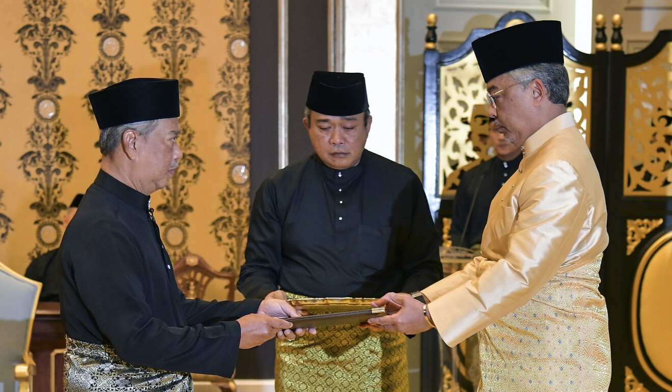 Malaysia's incoming Prime Minister Muhyiddin Yassin (left) receiving documents from Malaysia King Sultan Abdullah Sultan Ahmad Shah (right) before taking the oath as the country's new leader at the National Palace in Kuala Lumpur, Malaysia. Photo: Handout