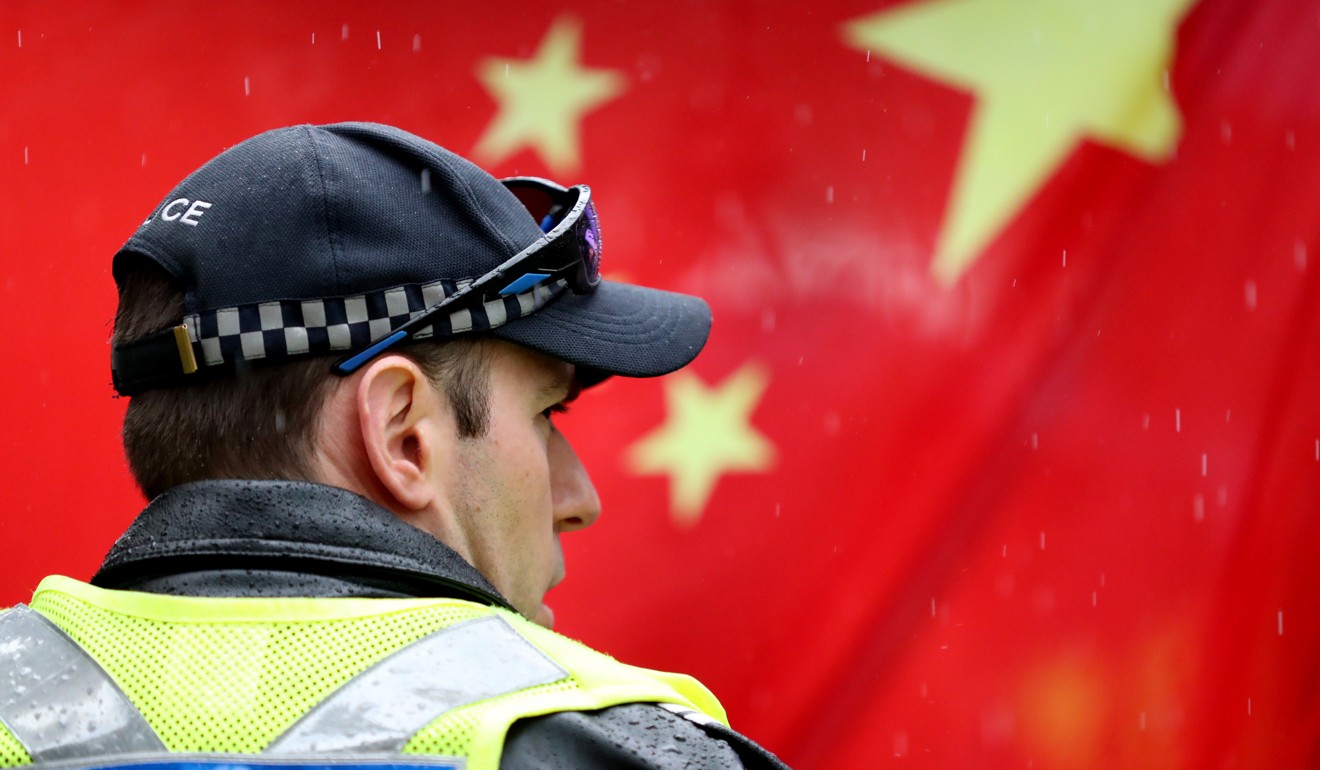 A police officer stands in front of a Chinese flag during a pro-democracy rally in Adelaide last year. Photo: EPA