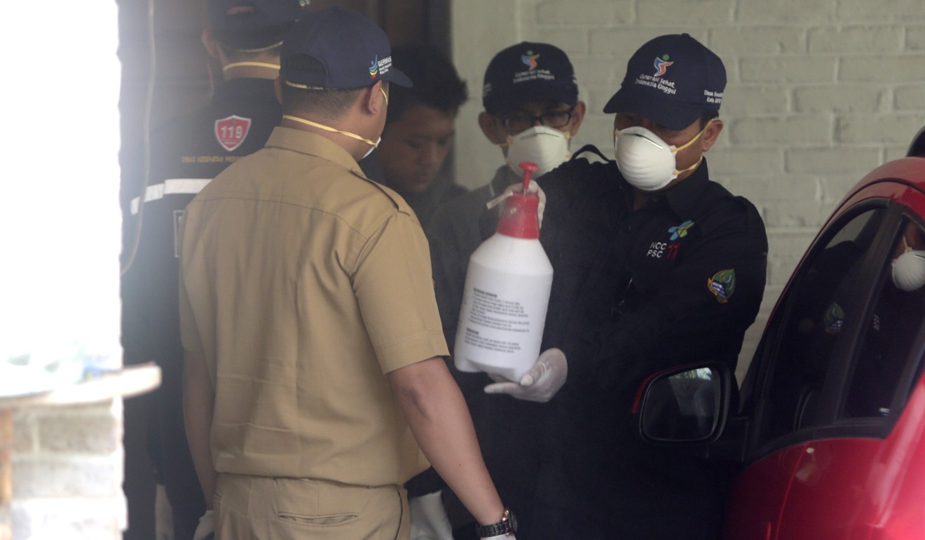 Health workers spray disinfectant at the residence of two people who tested positive for coronavirus in Depok, Indonesia. Photo: EPA-EFE