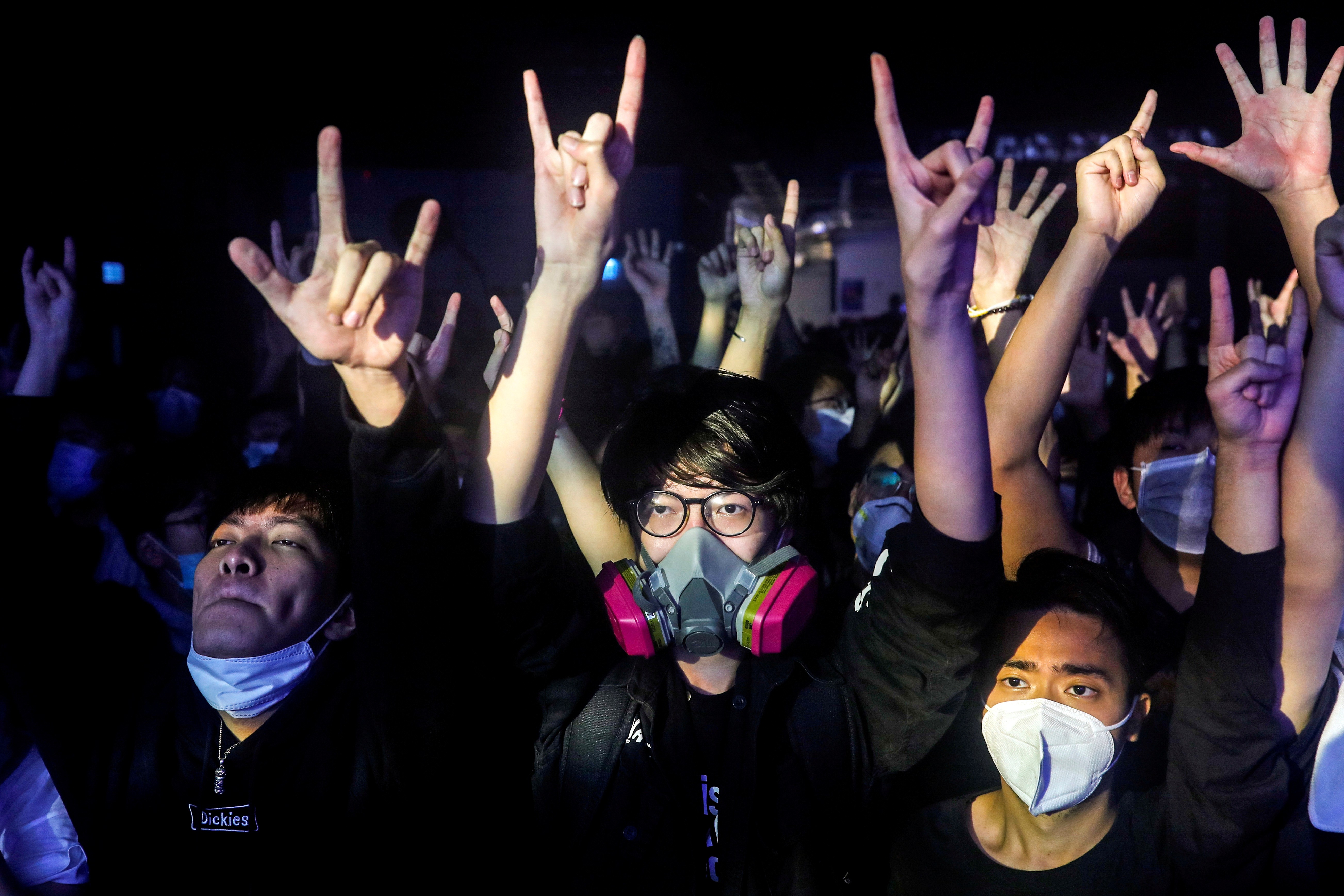 Fans wearing protective masks react while enjoying a band's performance at Hidden Agenda: This Town Needs (TNN). Photo: Reuters