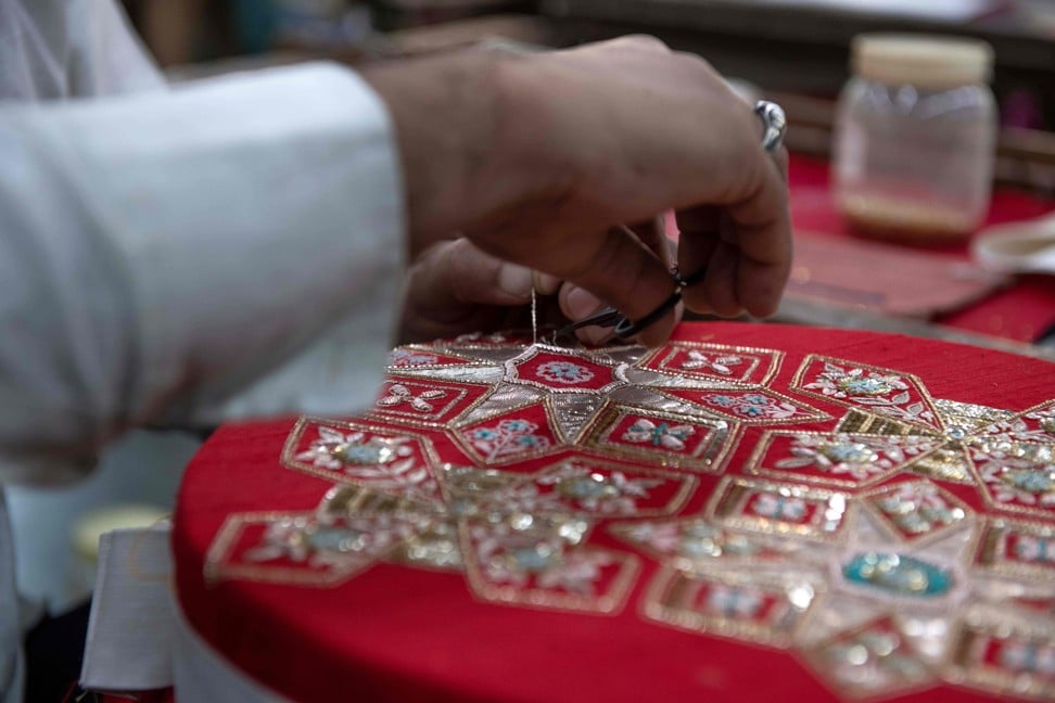 A man works on an embroidery at Dongre’s factory. Photo: AFP