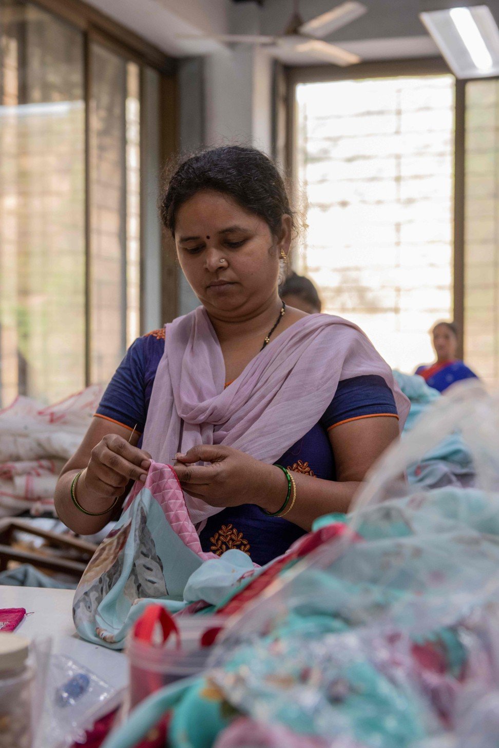 A woman sews a piece of cloth at Dongre’s factory. Photo: AFP