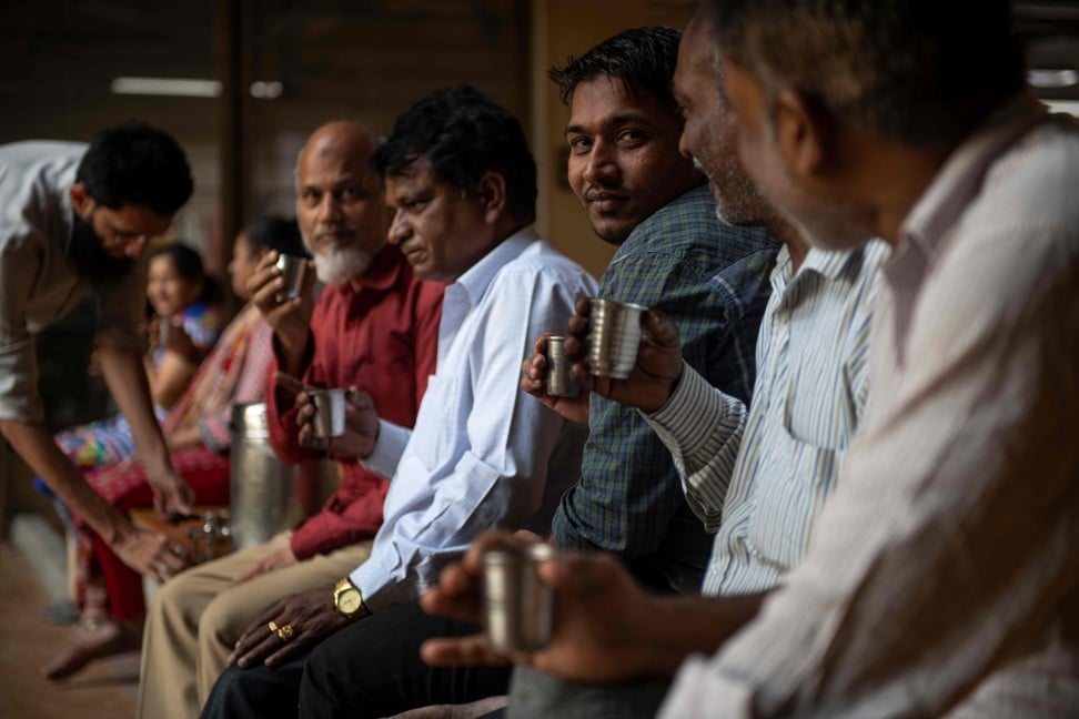 Men drink tea during a break at Dongre’s factory. Photo: AFP