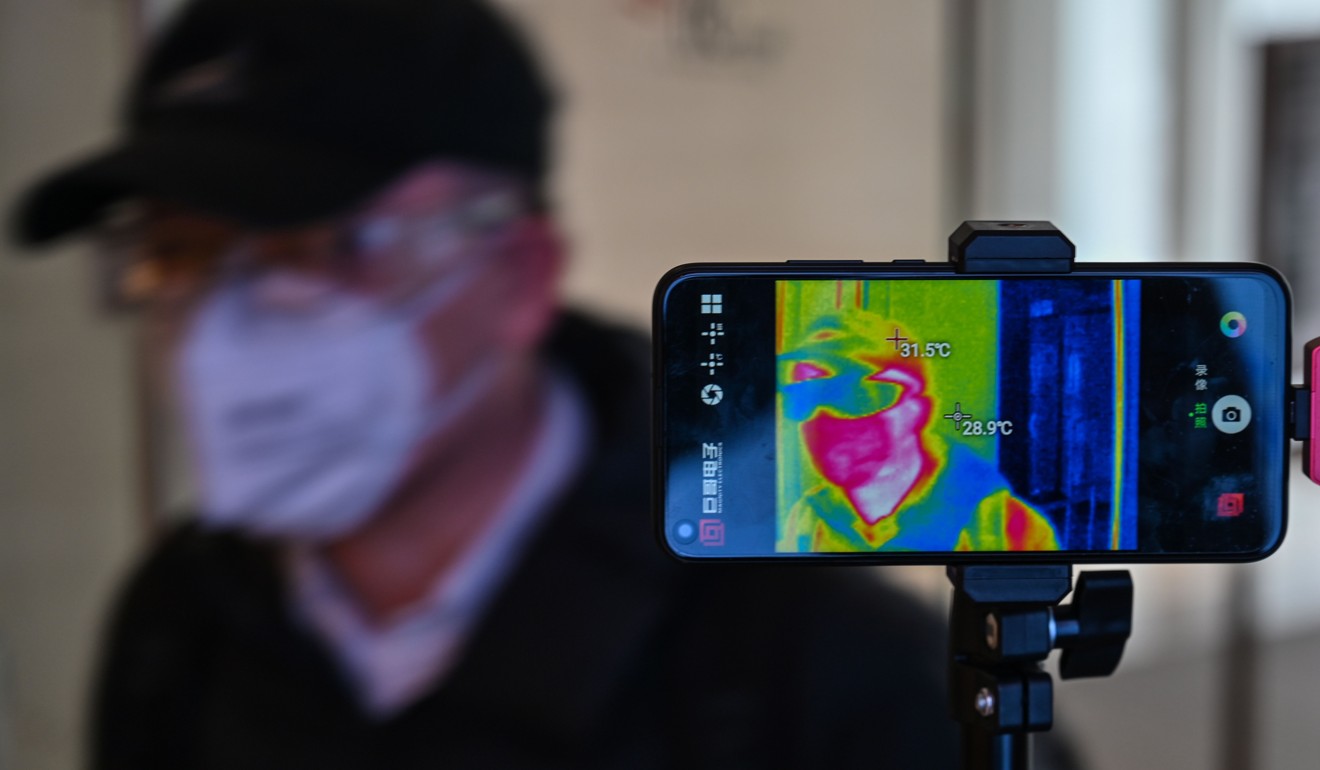 A man wearing a face mask has his temperature measured in at a shopping centre in Shanghai on Wednesday. Photo: AFP