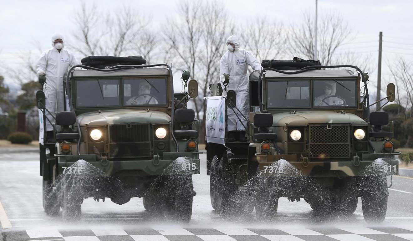Army trucks spray disinfectant as a precaution against the coronavirus on a street in Ulsan, South Korea. Photo: AP