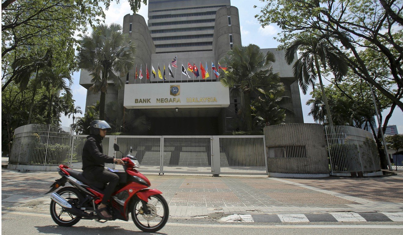 A motorcyclist rides past the Bank Negara Malaysia in Kuala Lumpur. Photo: AP