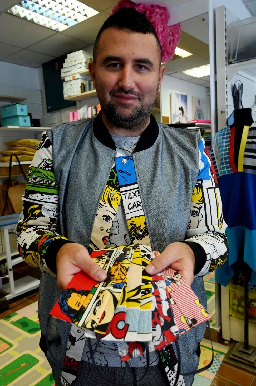 Croatian designer Aragovic shows a selection of face masks with his designs on them. Photo: AFP