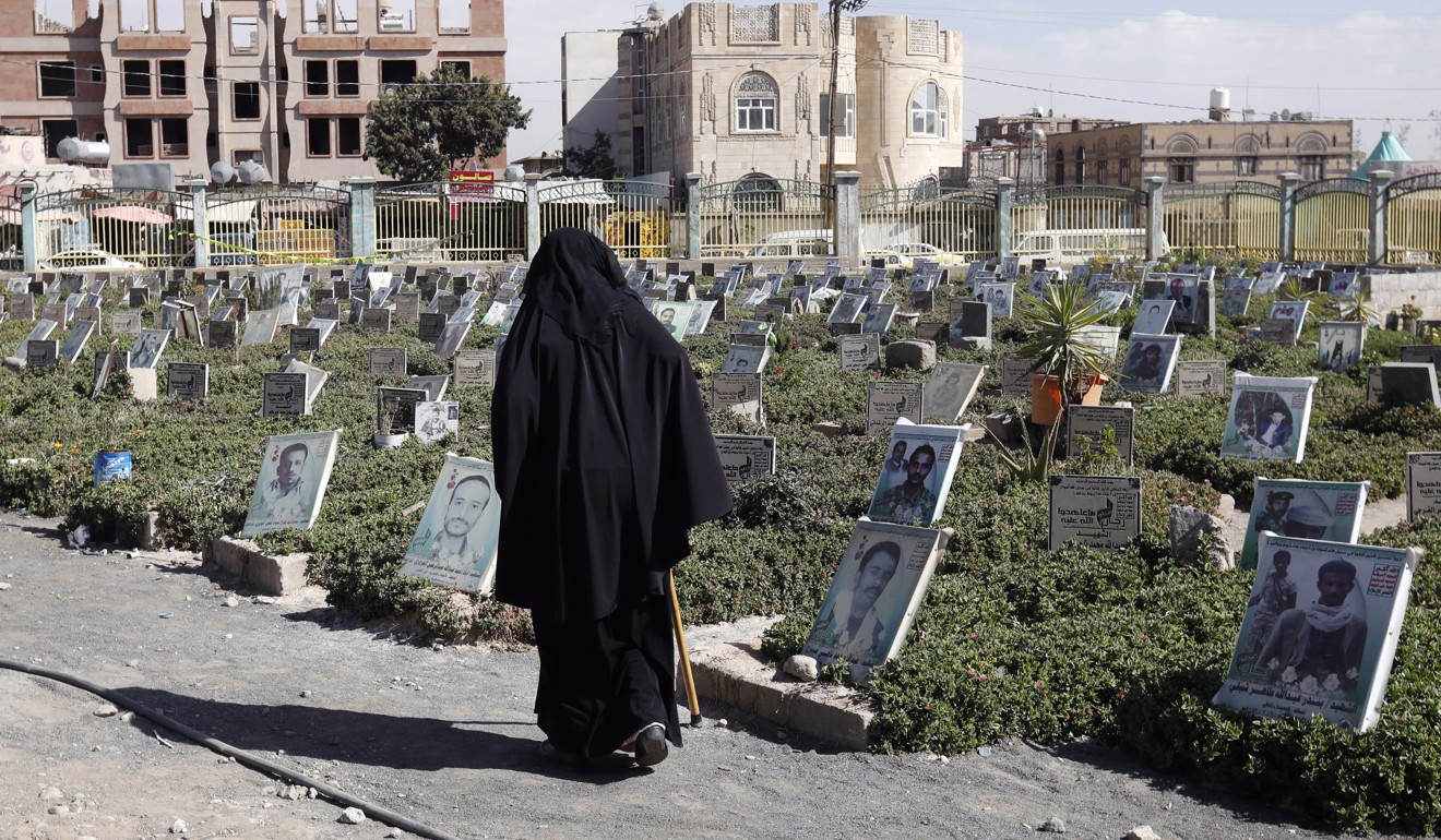A Yemeni woman walks past portraits on the graves of people allegedly killed in Yemen's prolonged fighting. Photo: EPA-EFE