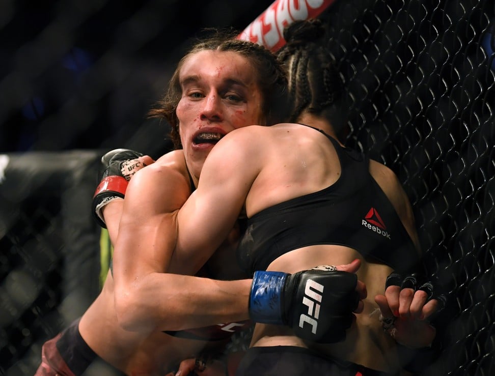 Joanna Jedrzejczyk hangs on to Zhang Weili during their UFC 248 war.