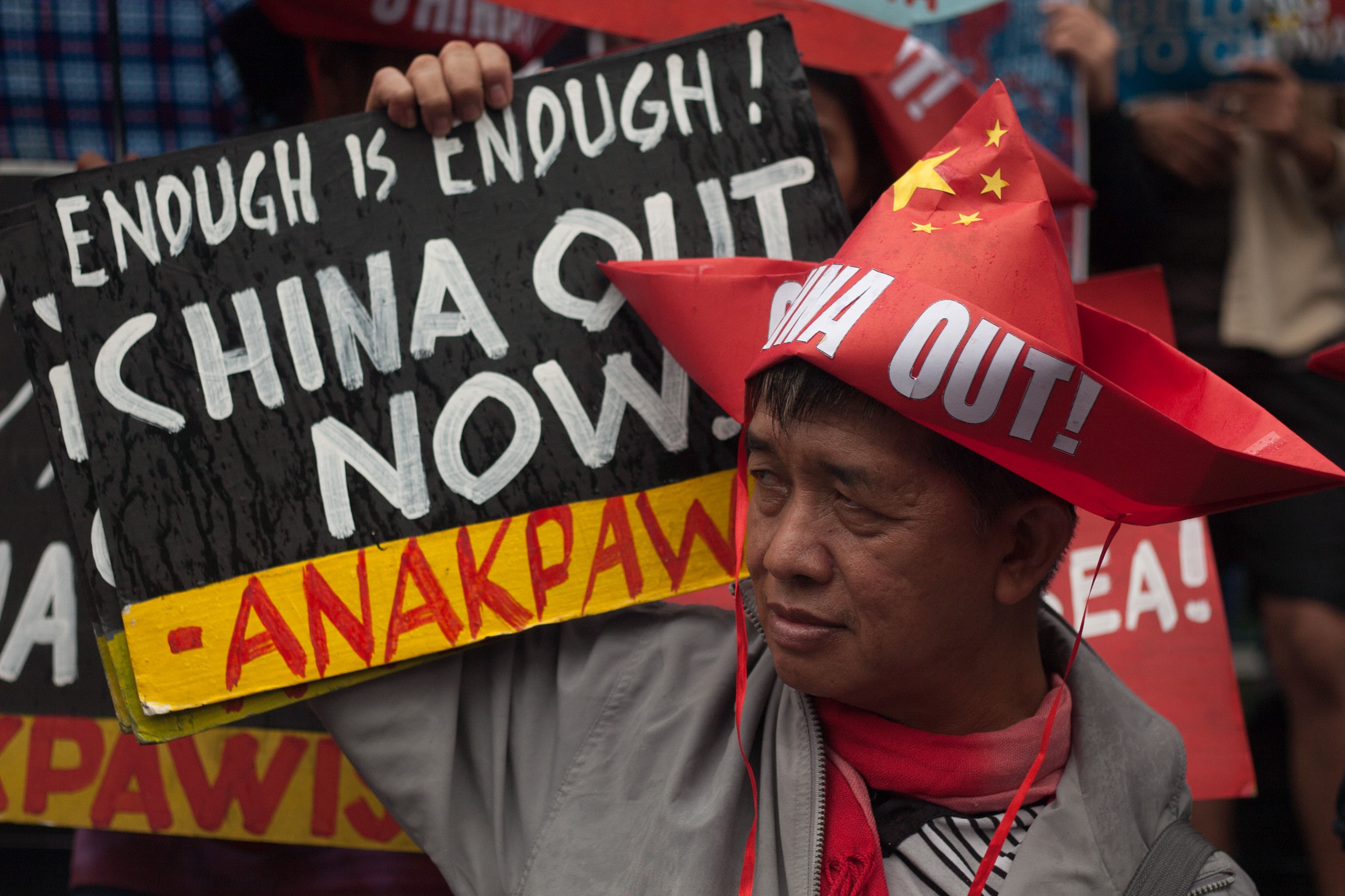 A protester holds a placard during a rally at the Chinese consulate in Manila, Philippines. Photo: Richard James Mendoza/NurPhoto