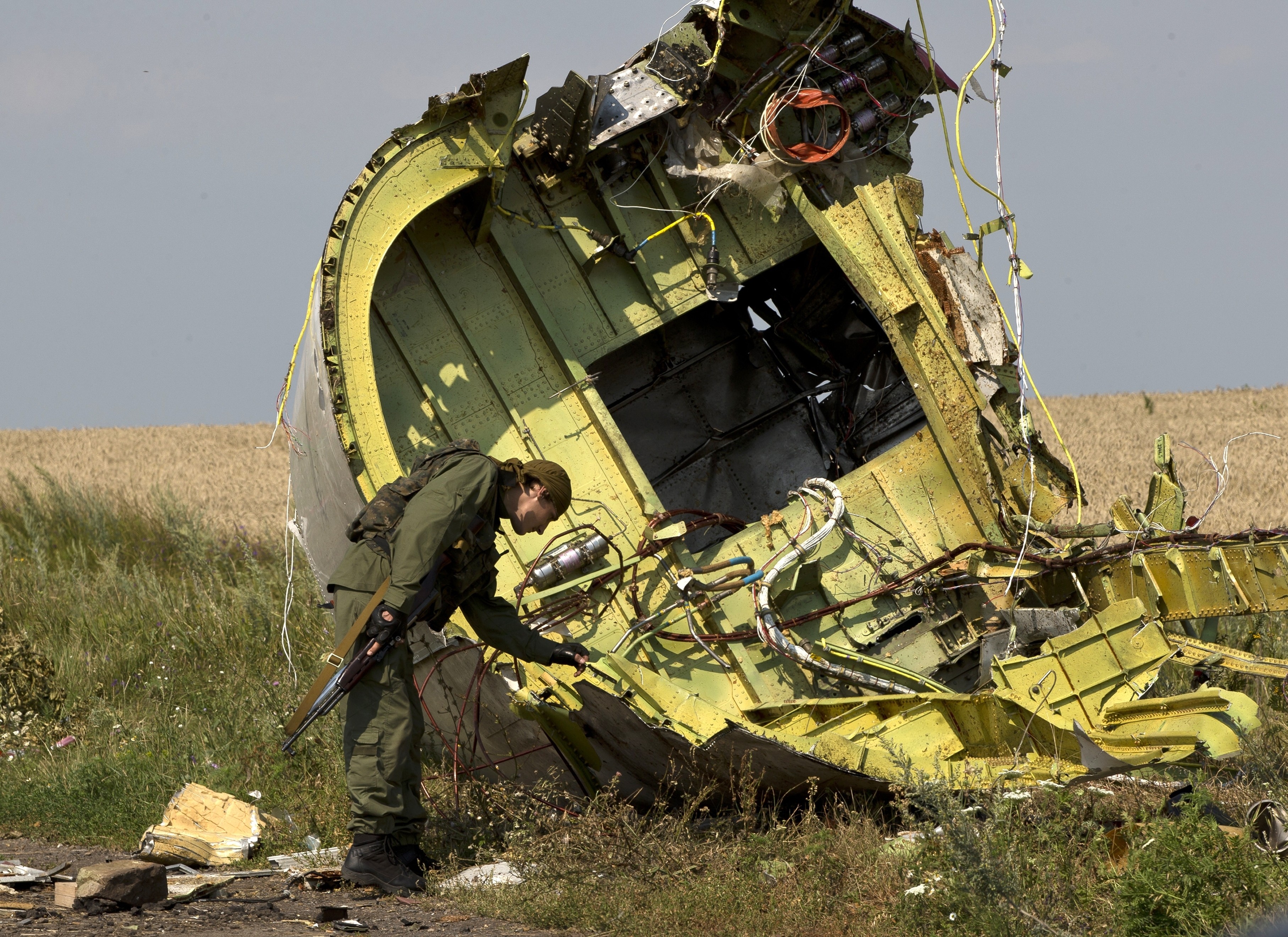 A pro-Russian rebel touches the MH17 wreckage at the crash site near the village of Hrabove, eastern Ukraine, in July 2014. Photo: AP