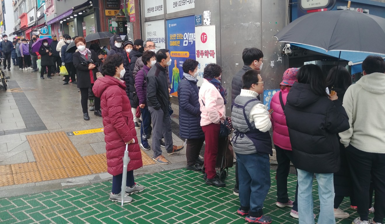 Une longue file d'attente se forme devant un magasin de Séoul pour acheter des masques qui sont en fait rationnés pour faire face aux pénuries au milieu de l'épidémie de coronavirus Covid-19. Photo: Parc Chan-kyong