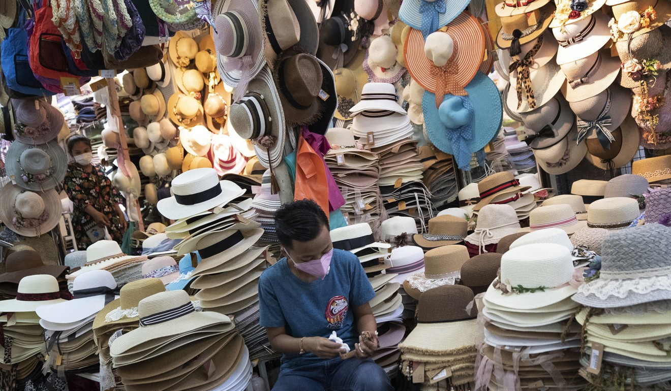 A vendor wears a protective mask as he waits for customers at an outdoor market in Bangkok. Photo: AP