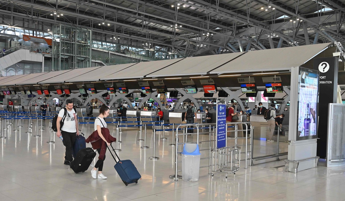 Travellers walk through the almost-empty departure hall of Bangkok’s Suvarnabhumi Airport on March 11. Photo: AFP