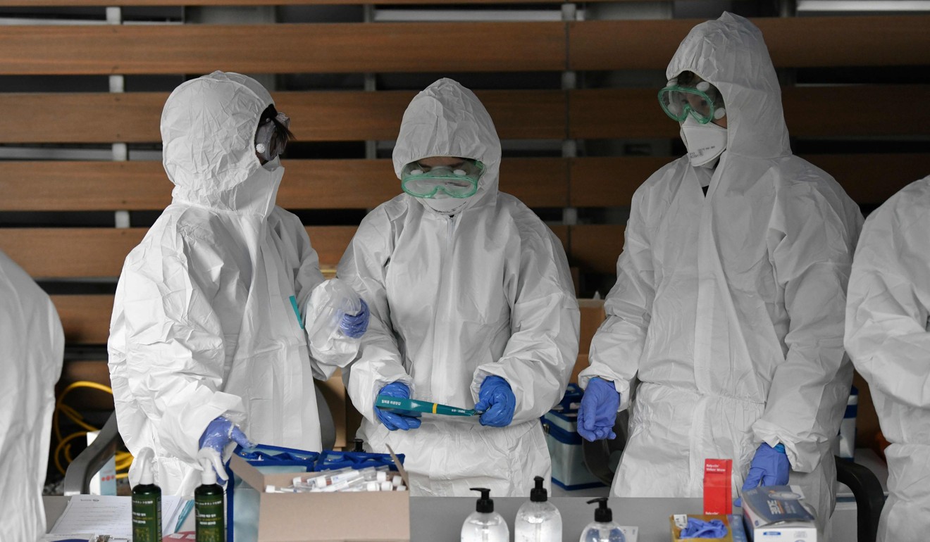 Medical workers wearing protective gear prepare to take samples from employees at a building in Seoul. Photo: AFP