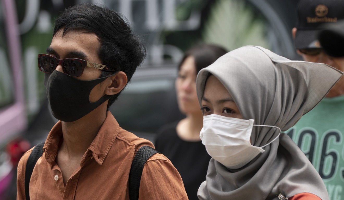 Pedestrians wearing protective face mask cross a street in downtown Kuala Lumpur earlier this month. Photo: AP