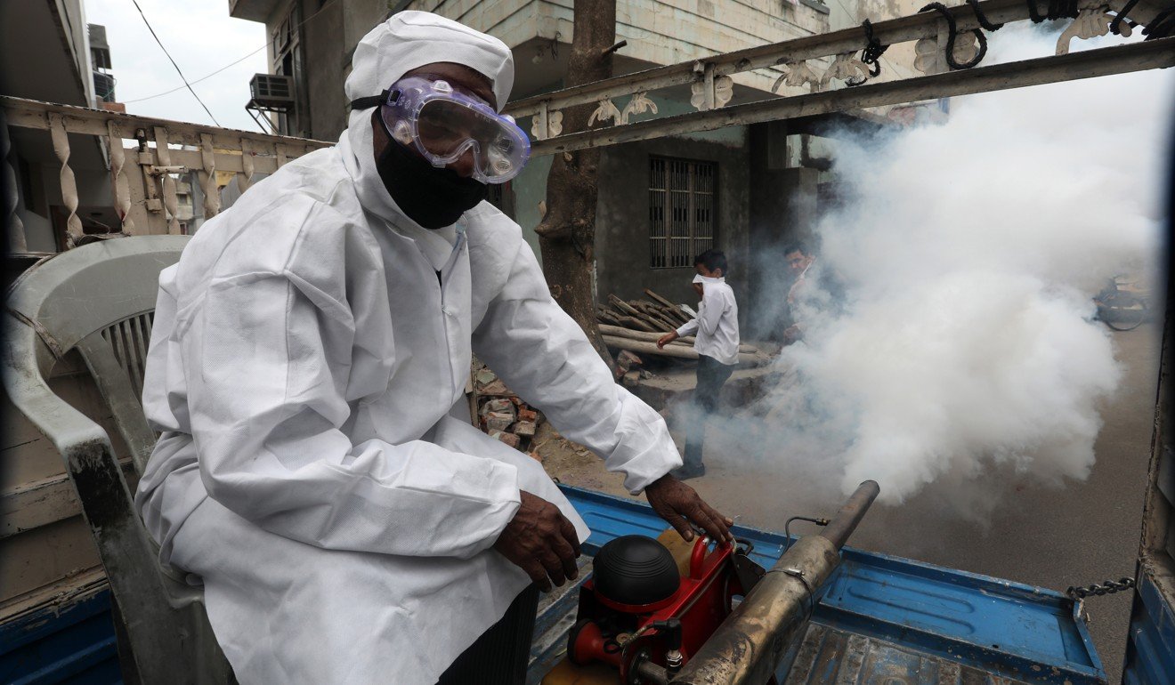 Jammu Municipal Corporation employees carry out disinfection on the streets in Jammu, India on Wednesday. Photo: EPA-EFE