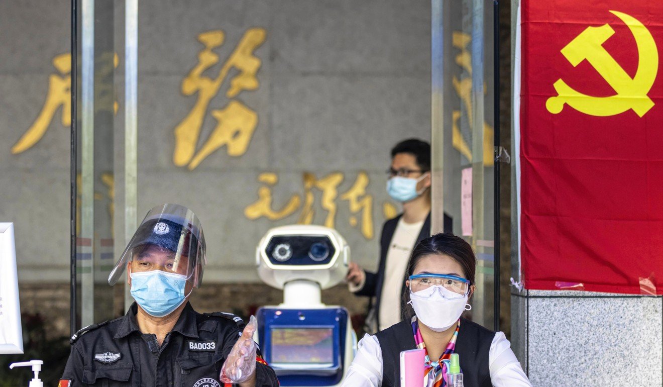 e A robot checks visitors' body temperatures for possible coronavirus infections at the entrance of a government building in Guangzhou. Photo: EPA-EFE