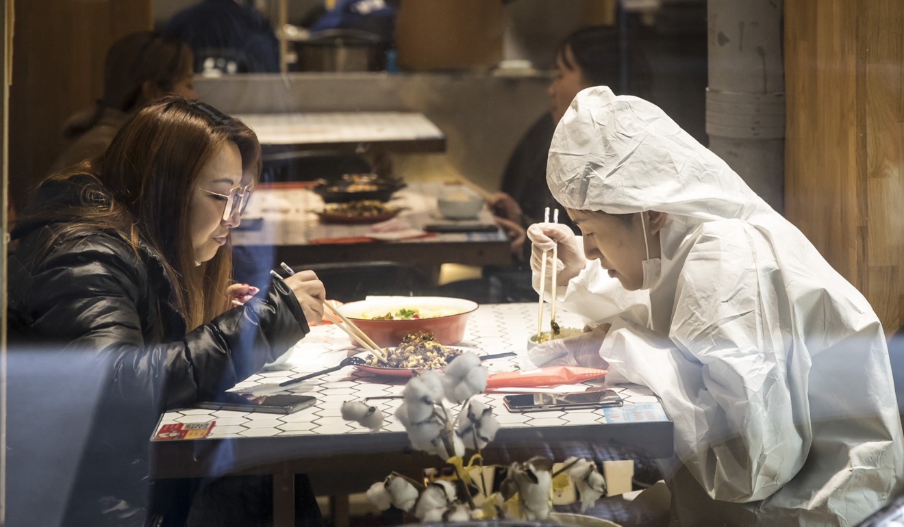 A woman takes no chances as she tucks into a meal at a restaurant in Shanghai. Photo: Bloomberg