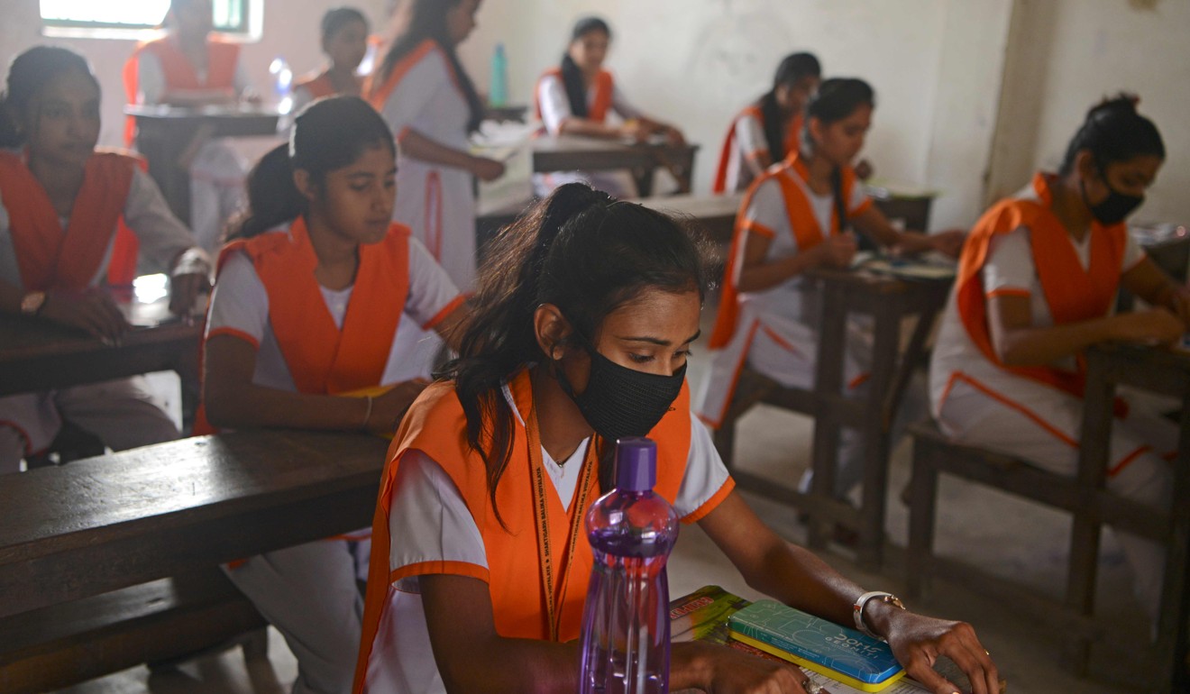 Students get ready to take an exam while wearing face masks at a school in Siliguri, India. Photo: AFP